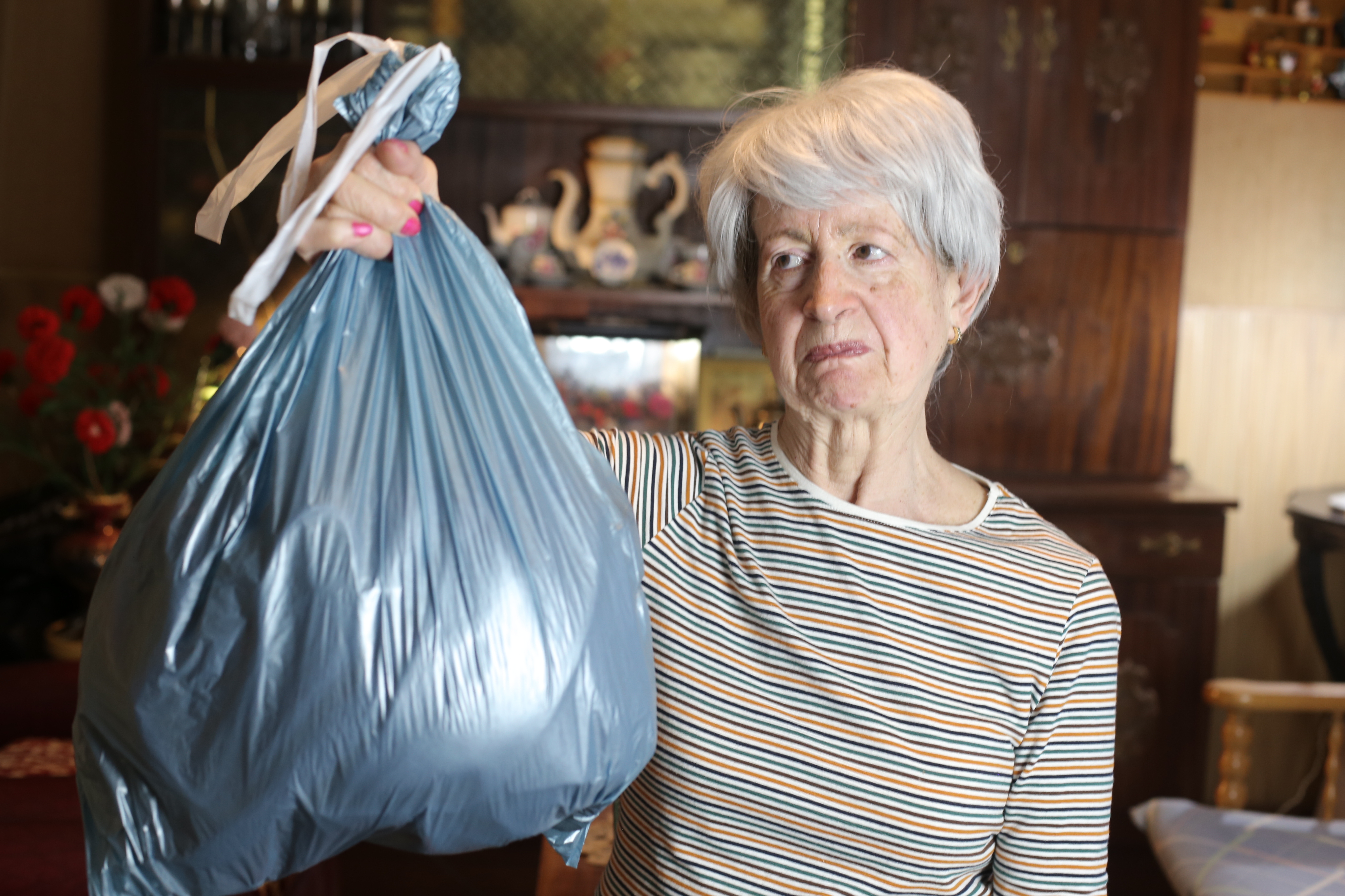 Mujer mayor sujetando una bolsa de basura | Foto: Getty Images