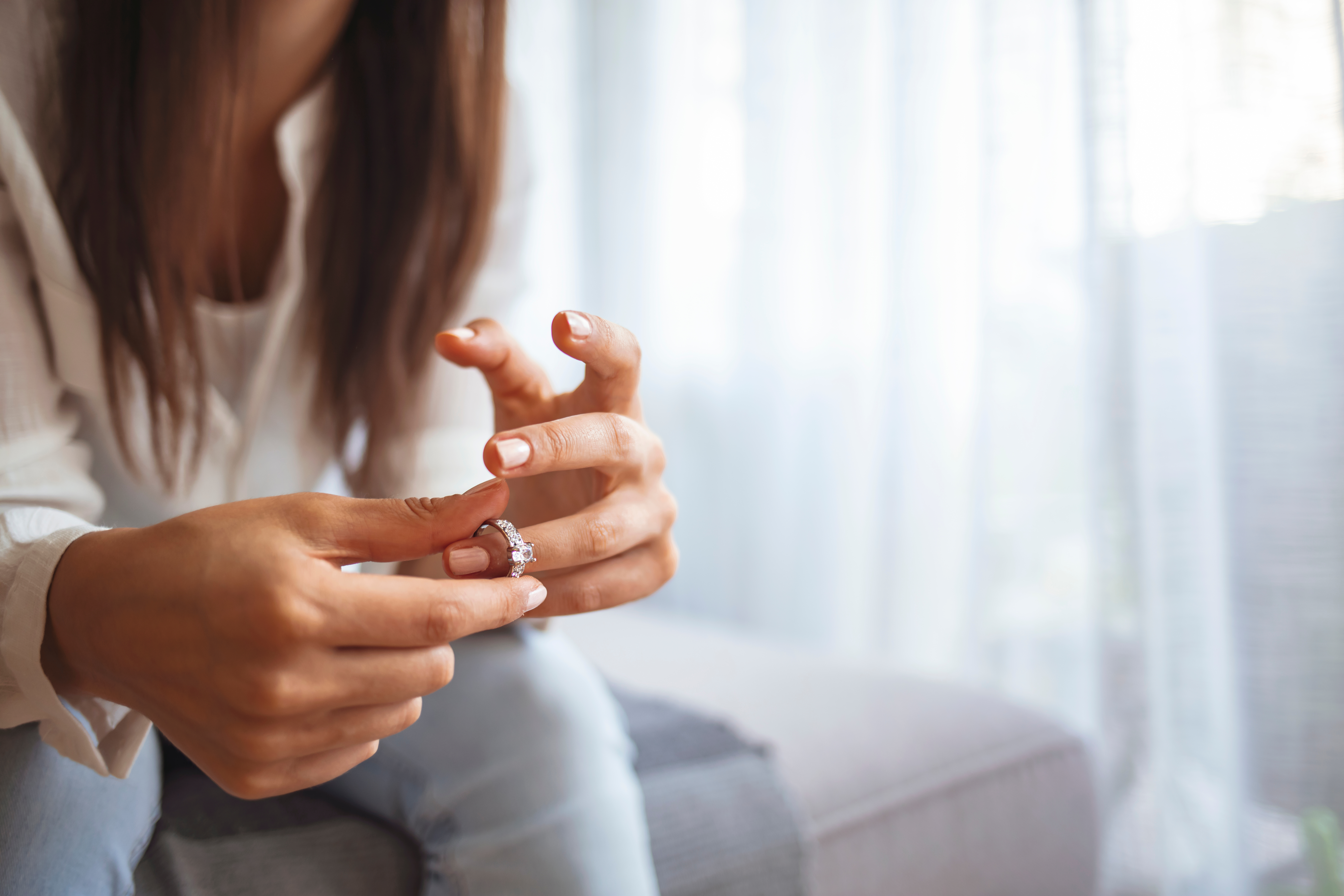 Una mujer quitándose el anillo de boda | Fuente: Shutterstock