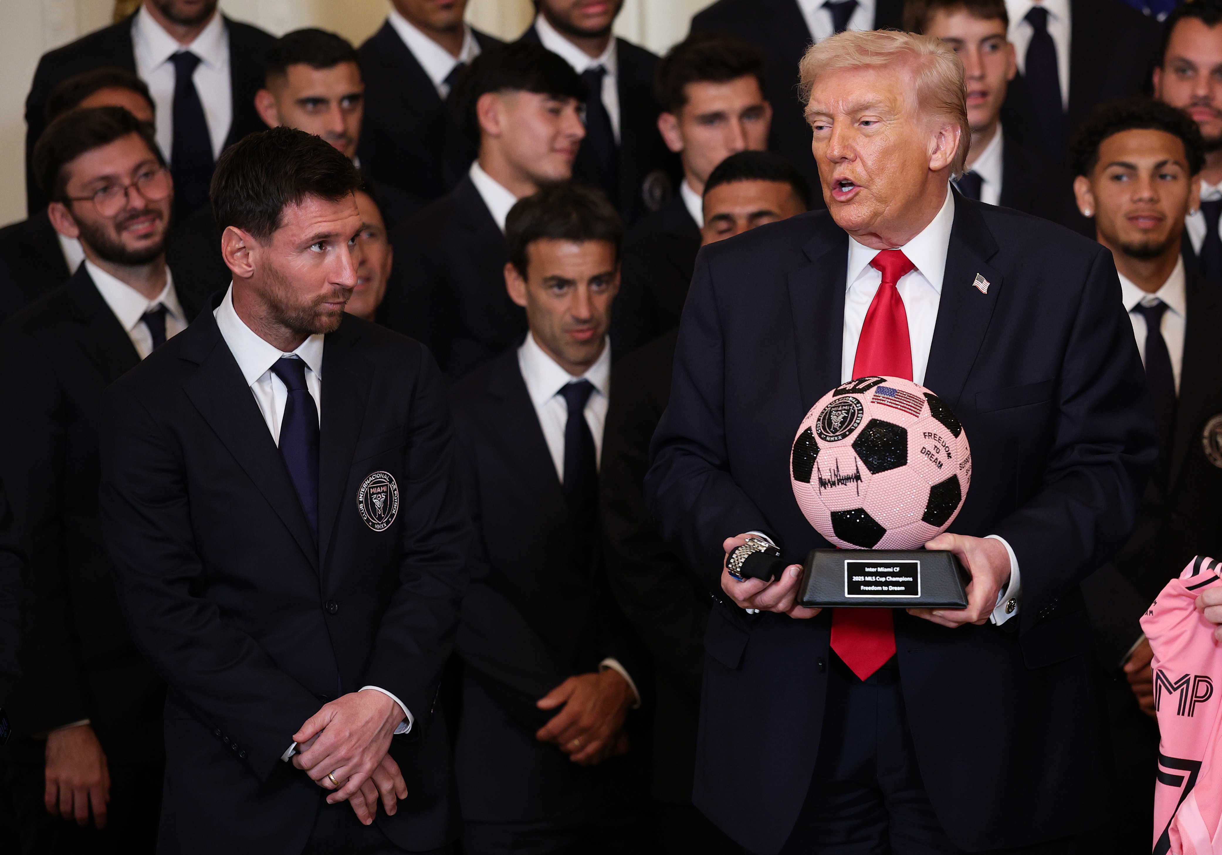 El presidente de Estados Unidos, Donald Trump, recibe regalos mientras Lionel Messi y otros miembros del Inter Miami observan durante un evento en honor al Inter Miami CF, campeón de la Copa MLS 2025, en el Salón Este de la Casa Blanca el 5 de marzo de 2026 en Washington, D.C. | Fuente: Getty Images