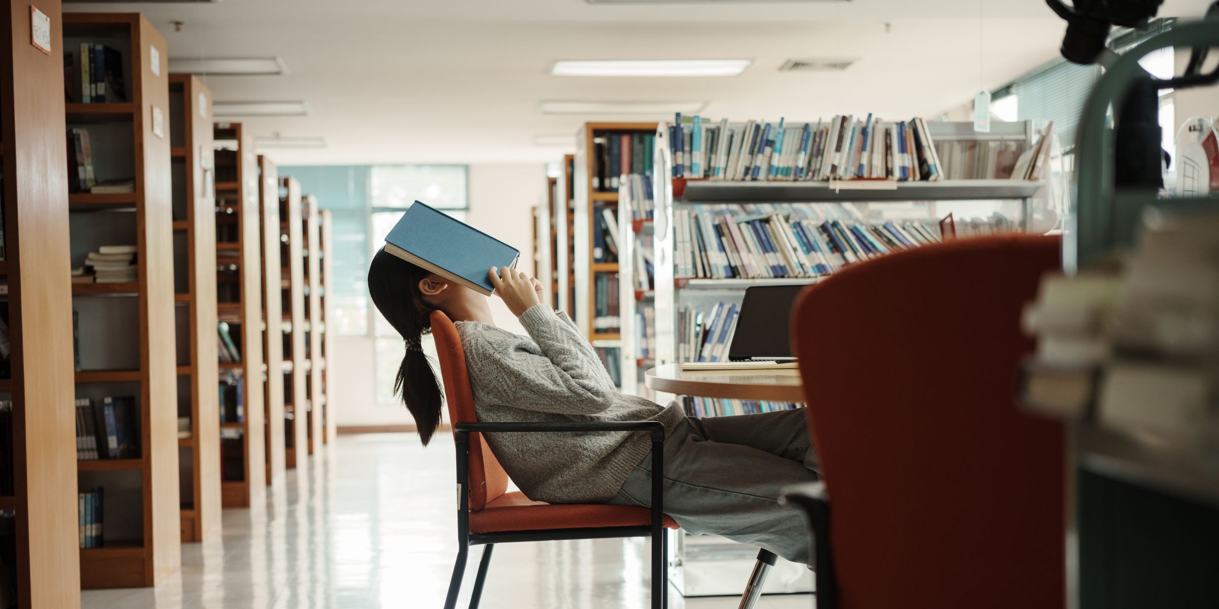 Chica estresada en la biblioteca | Fuente: Shutterstock