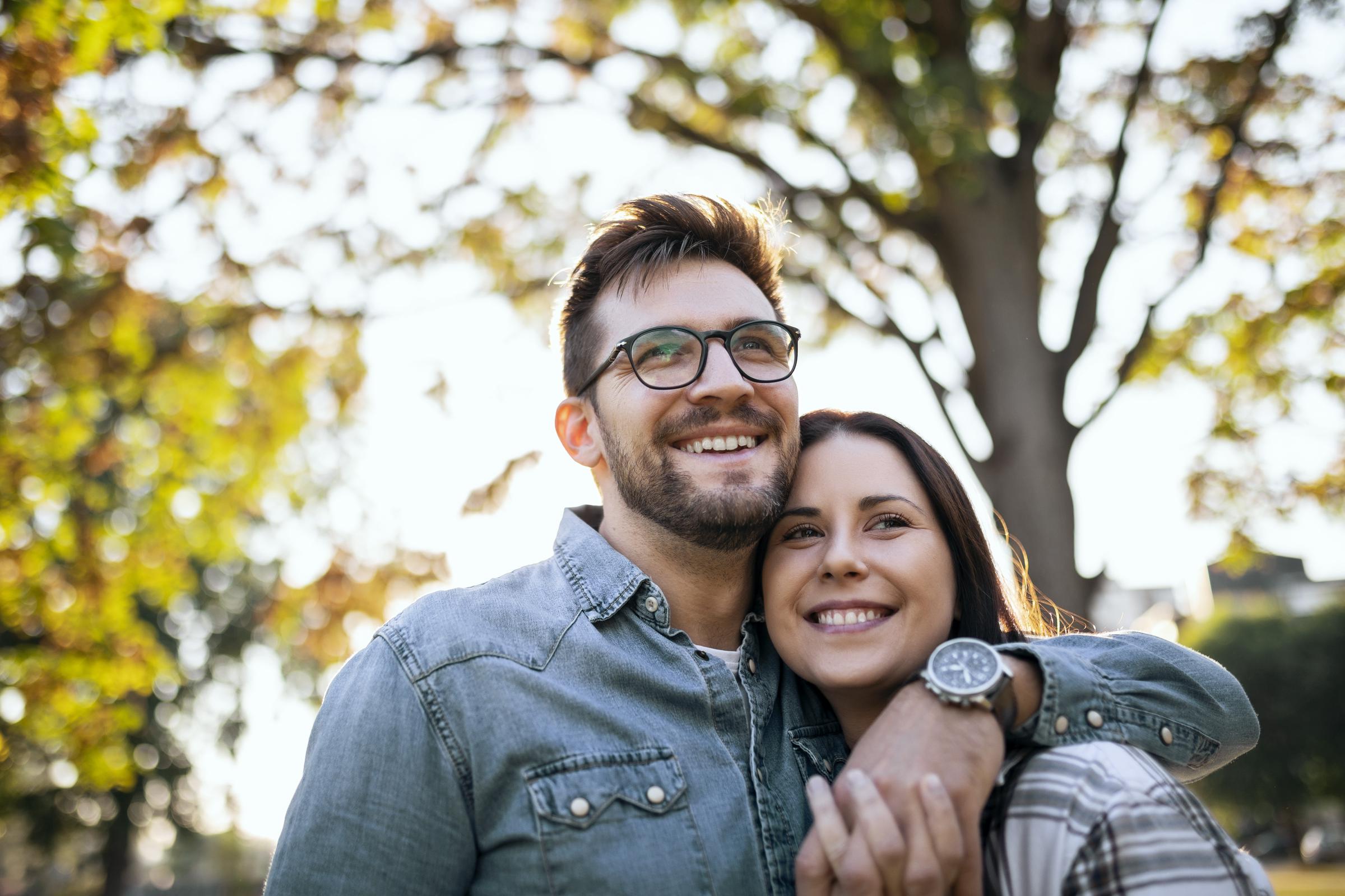 Pareja feliz paseando por un parque público | Fuente: Getty Images