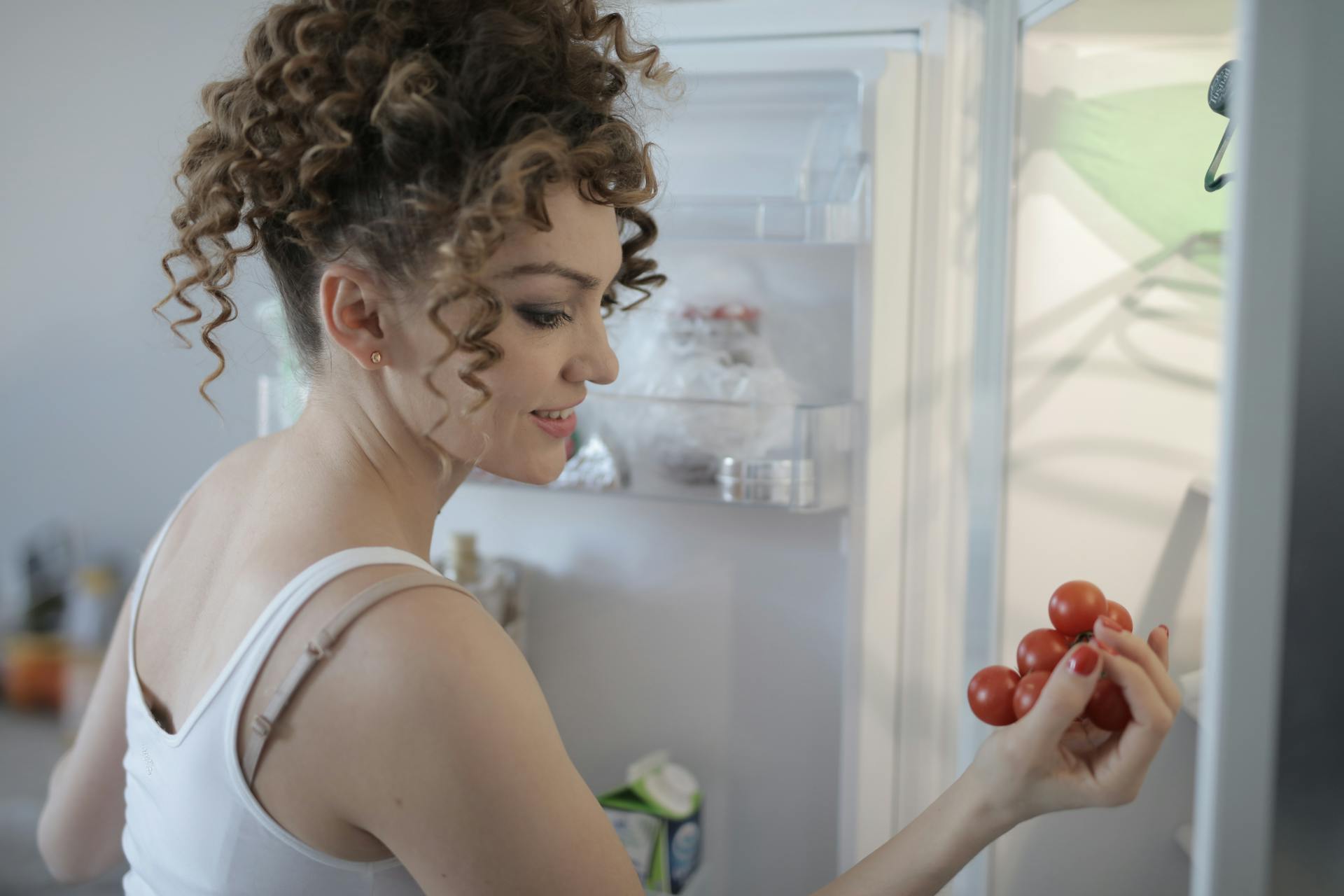 Una mujer organizando comida en un frigorífico | Fuente: Pexels