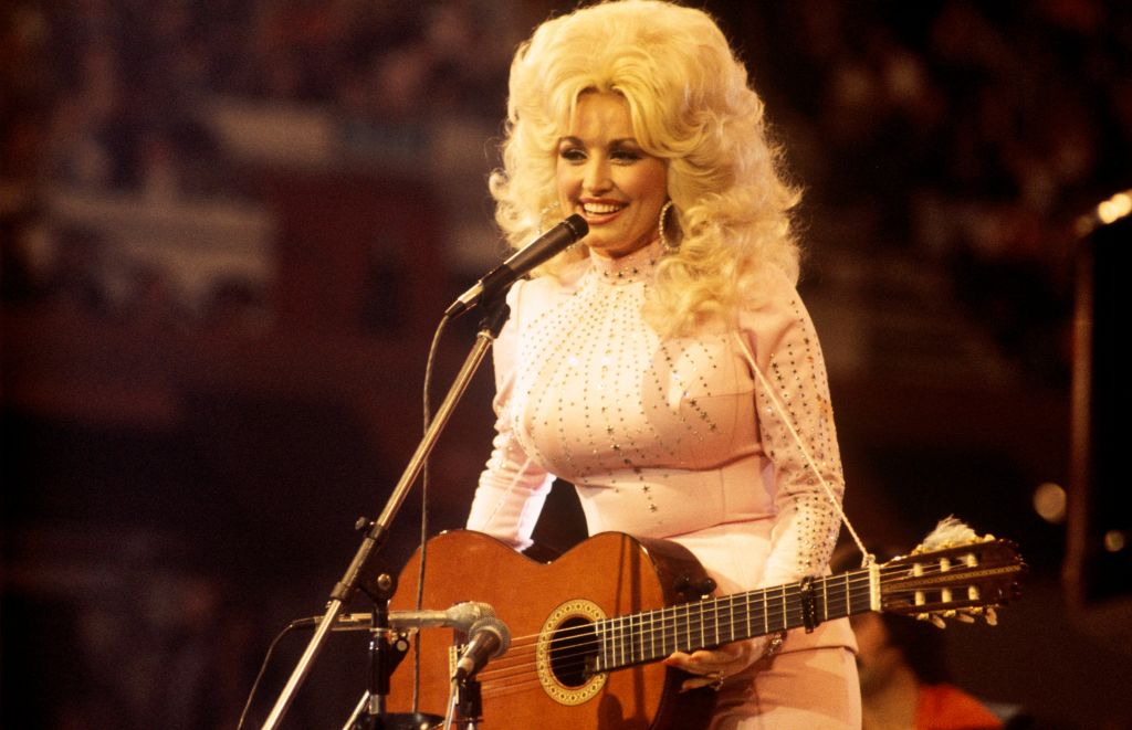La cantante, compositora y actriz estadounidense Dolly Parton, actuando con una guitarra, 1976. | Fuente: Getty Images