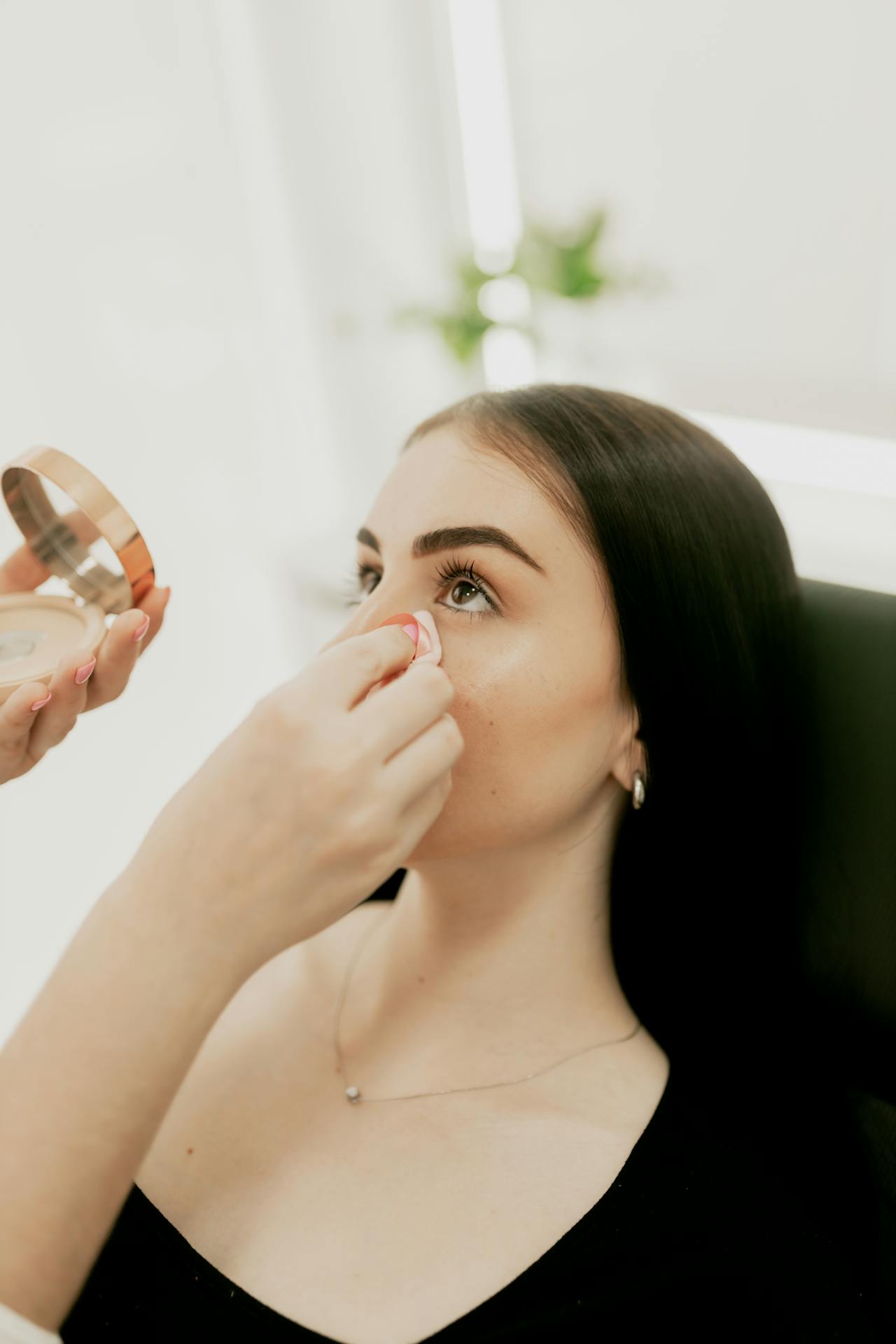Una mujer retocando la cara de una joven | Fuente: Pexels