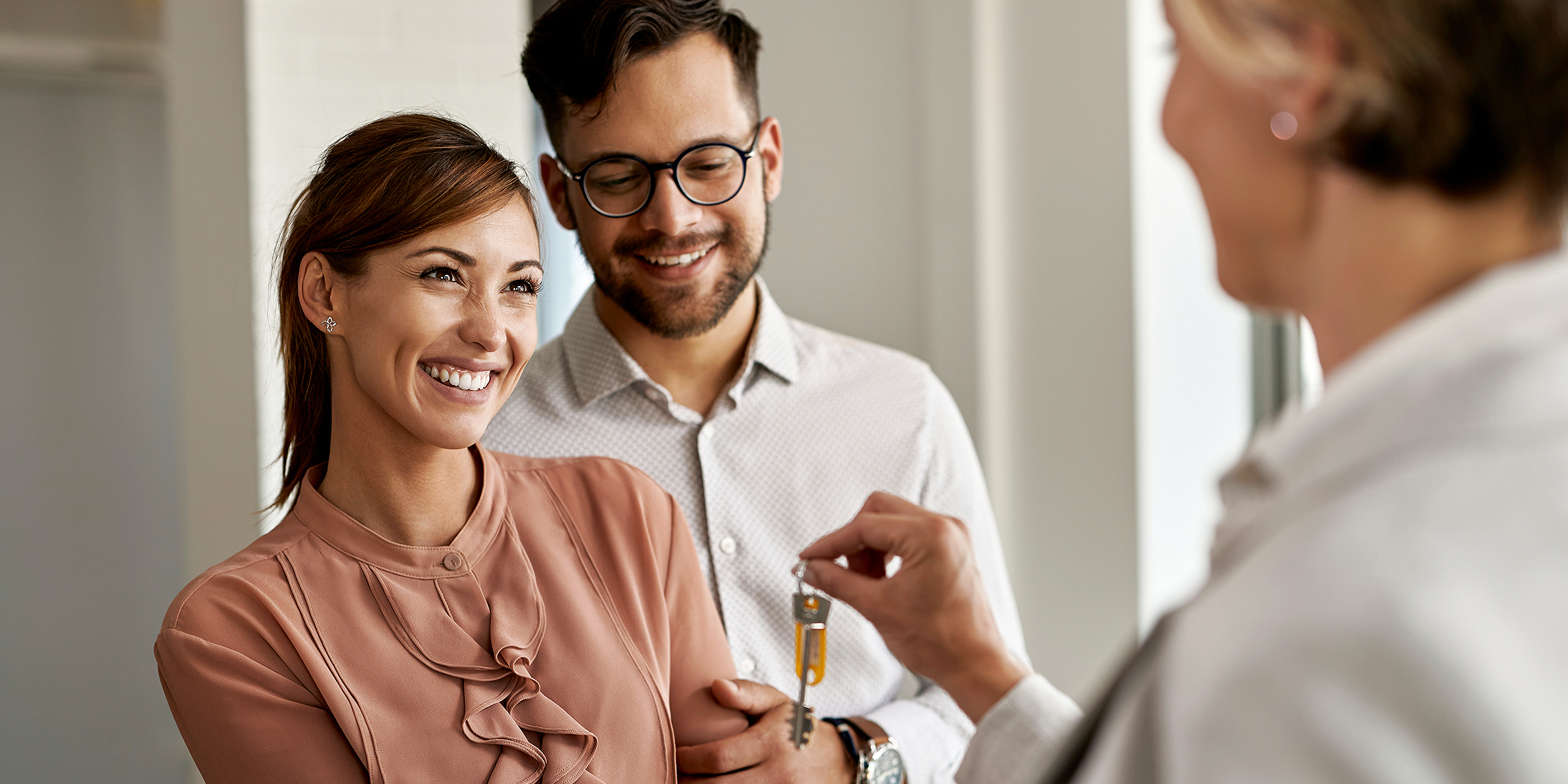 Una pareja feliz aceptando un juego de llaves | Fuente: Shutterstock