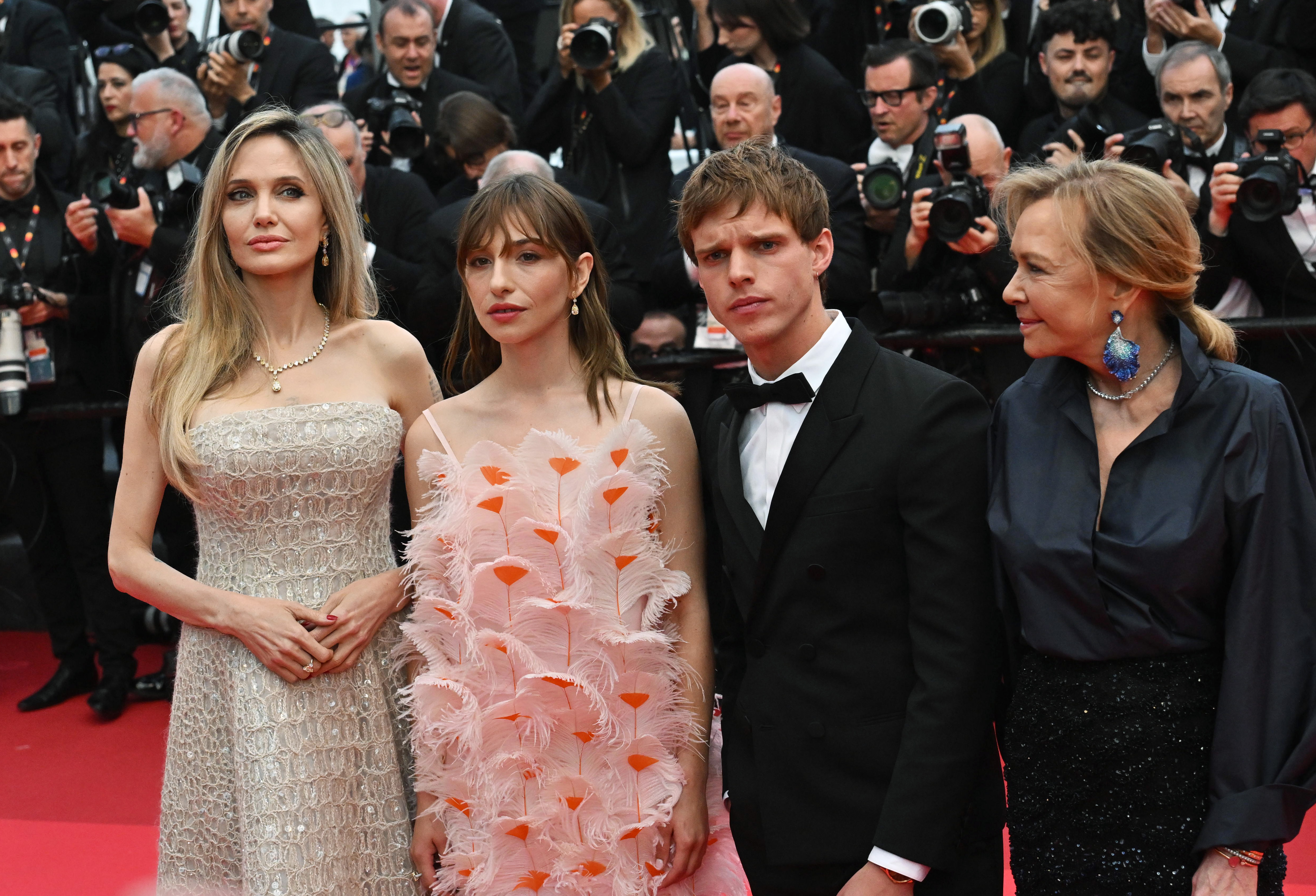 Angelina Jolie posa junto a Marie Colomb, Finn Bennett y Caroline Scheufele en el estreno de "Eddington". Vestida con un deslumbrante vestido de gala color champán, Jolie aporta un glamour refinado al retrato grupal, rodeada de coprotagonistas y colaboradores en medio de una tormenta de flashes.
