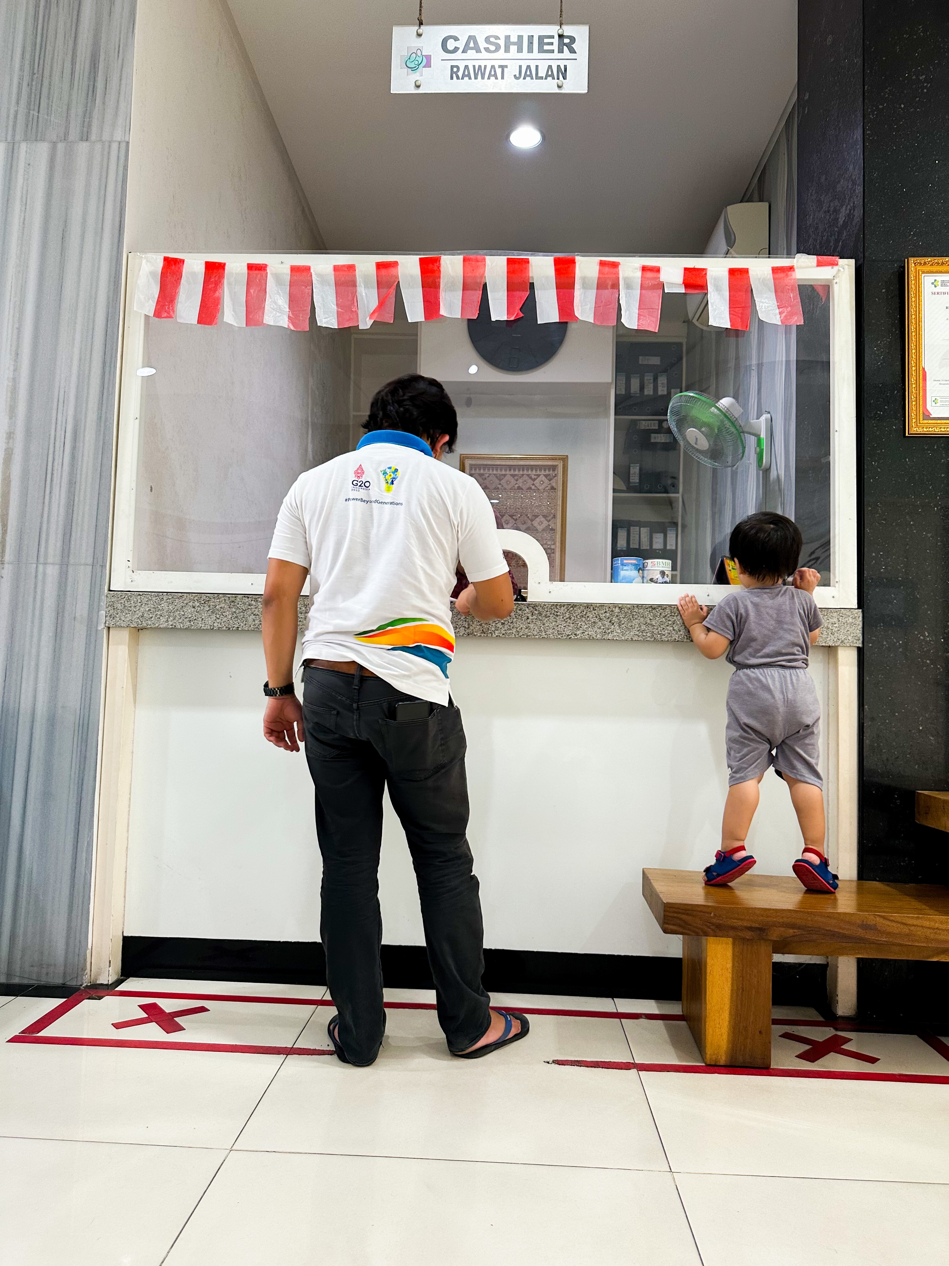 Un hombre delante del cajero con su hijo | Fuente: Shutterstock