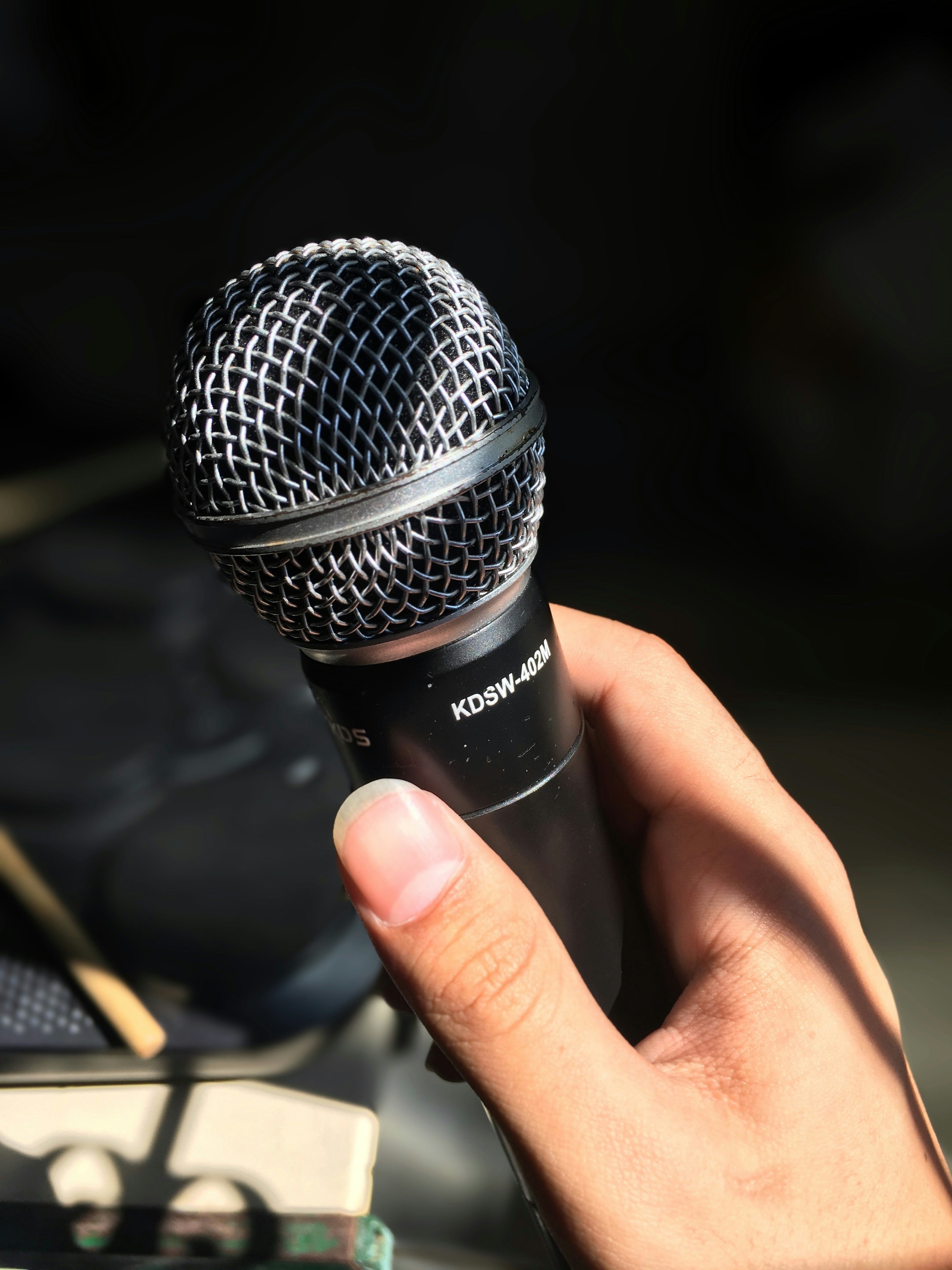 Primer plano de una persona sujetando un micrófono | Fuente: Unsplash