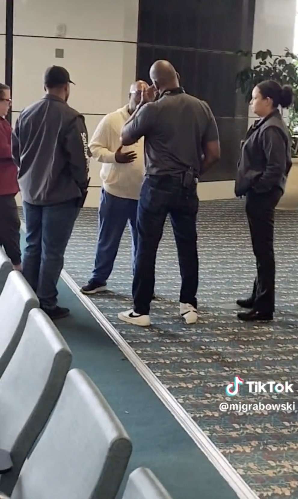 El pasajero molesto siendo abordado por las autoridades del aeropuerto de Orlando y agentes de policía | Foto: TikTok/mjgrabowski