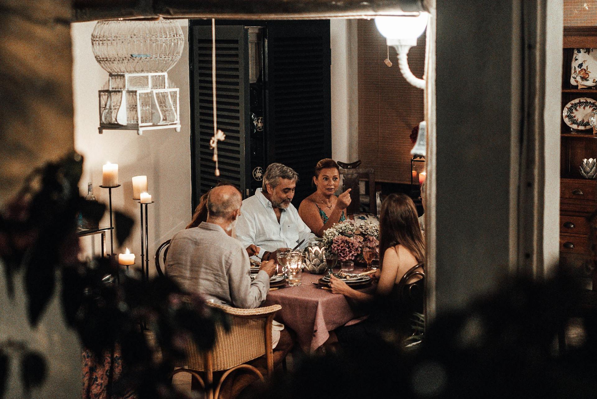 Un grupo de personas sentadas juntas a la mesa del comedor | Fuente: Pexels