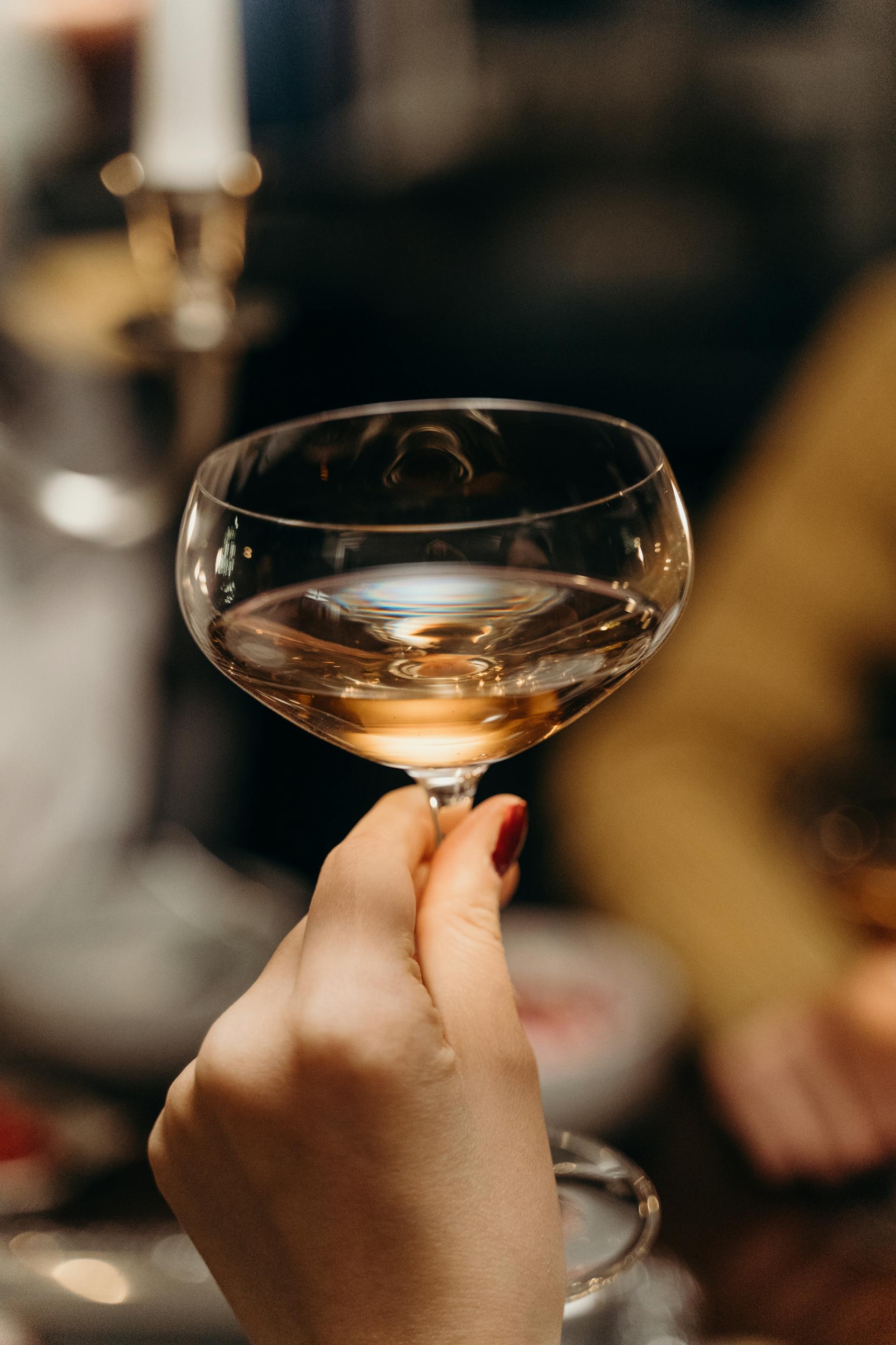Un primo piano di una donna che tiene in mano una coppa di champagne | Fonte: Pexels