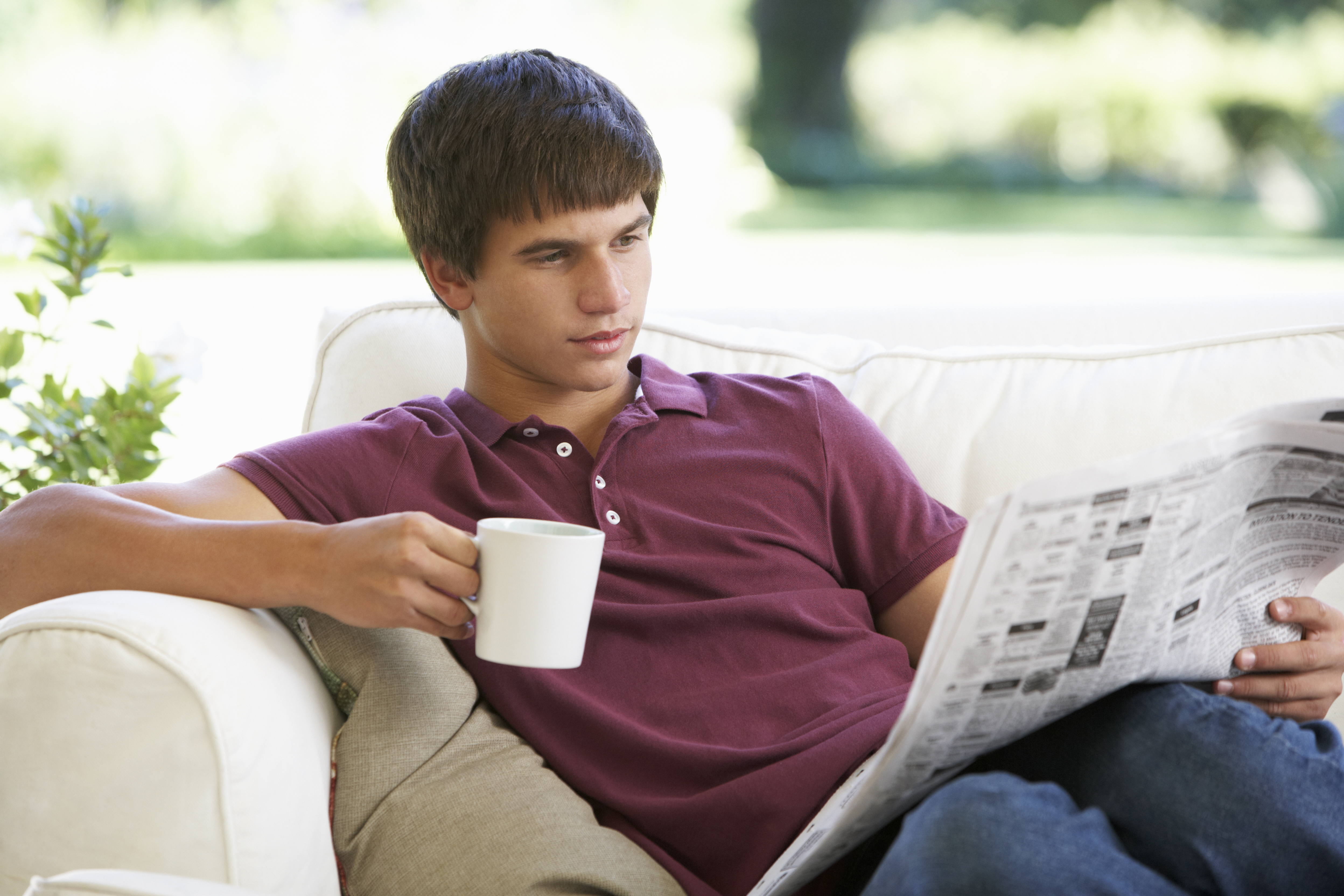 Un adolescente lee un periódico | Foto: Shutterstock