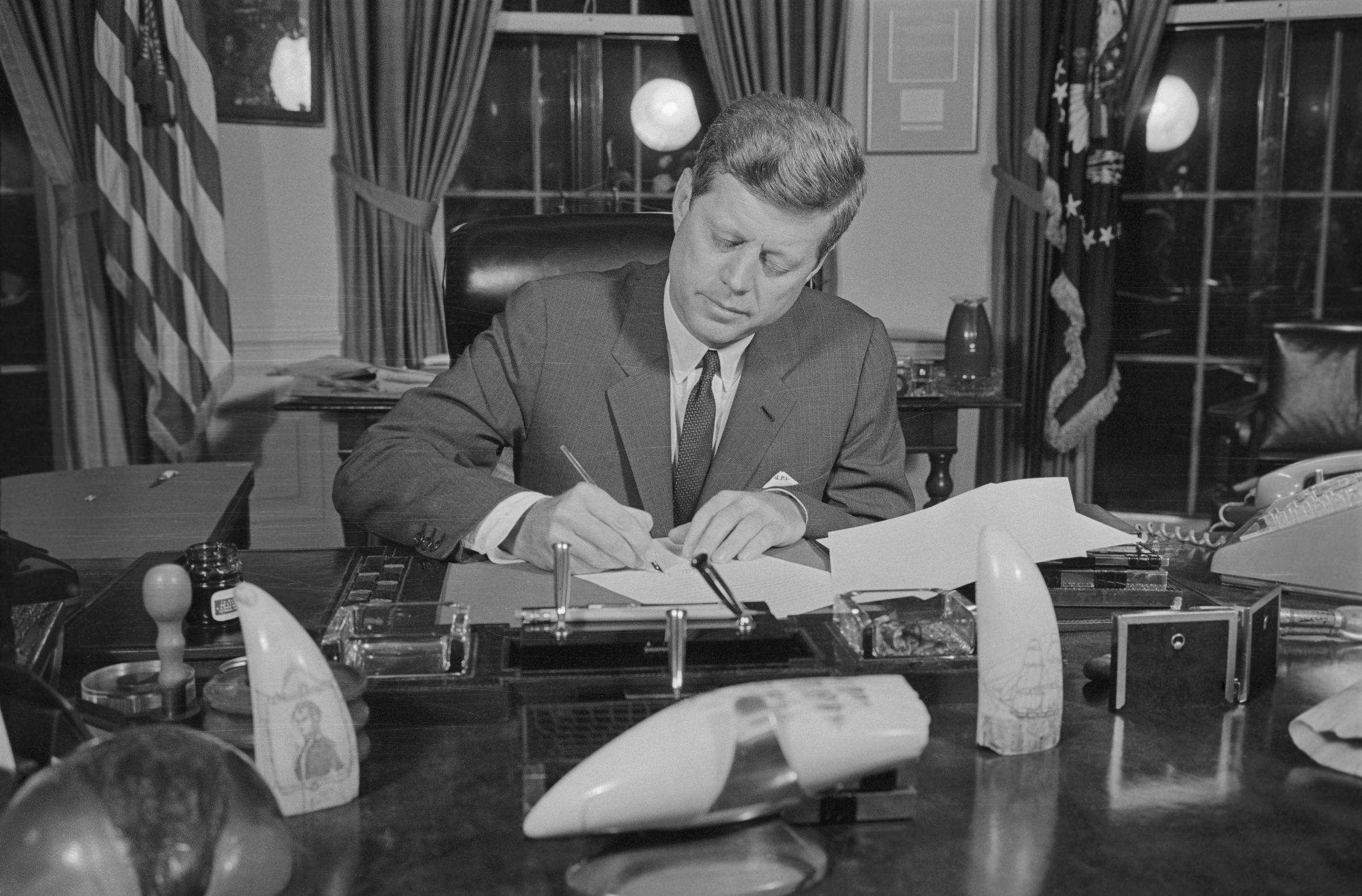 El ex presidente John F. Kennedy firmando la Orden de Bloqueo en su despacho en 1962. | Fuente: Getty Images