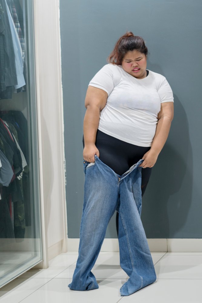 Mujer tratando de ponerse pantalones. | Foto: Shutterstock.