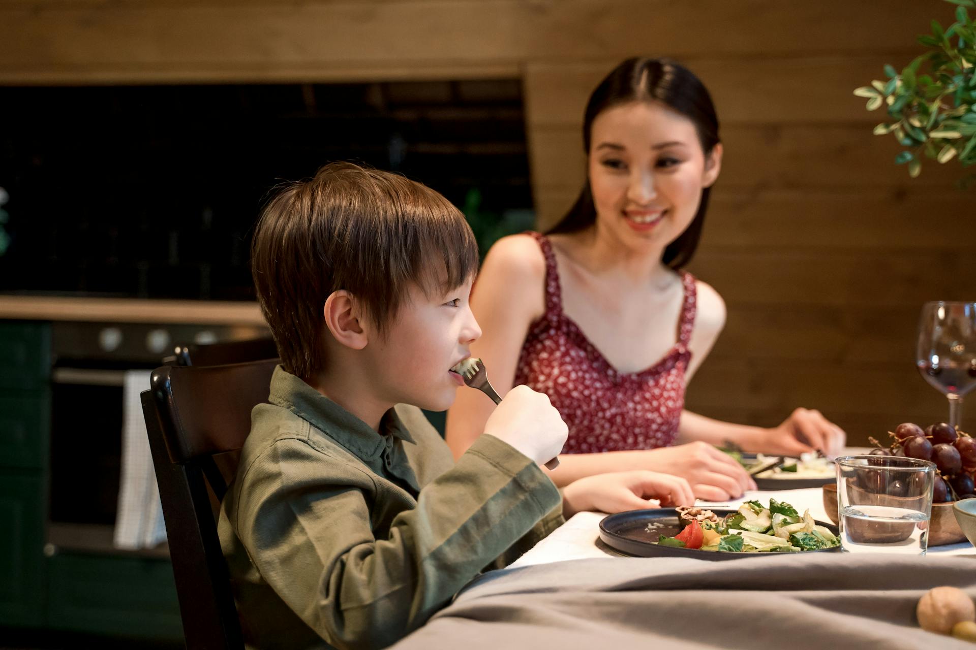 Una madre feliz y su hijo cenando | Fuente: Pexels