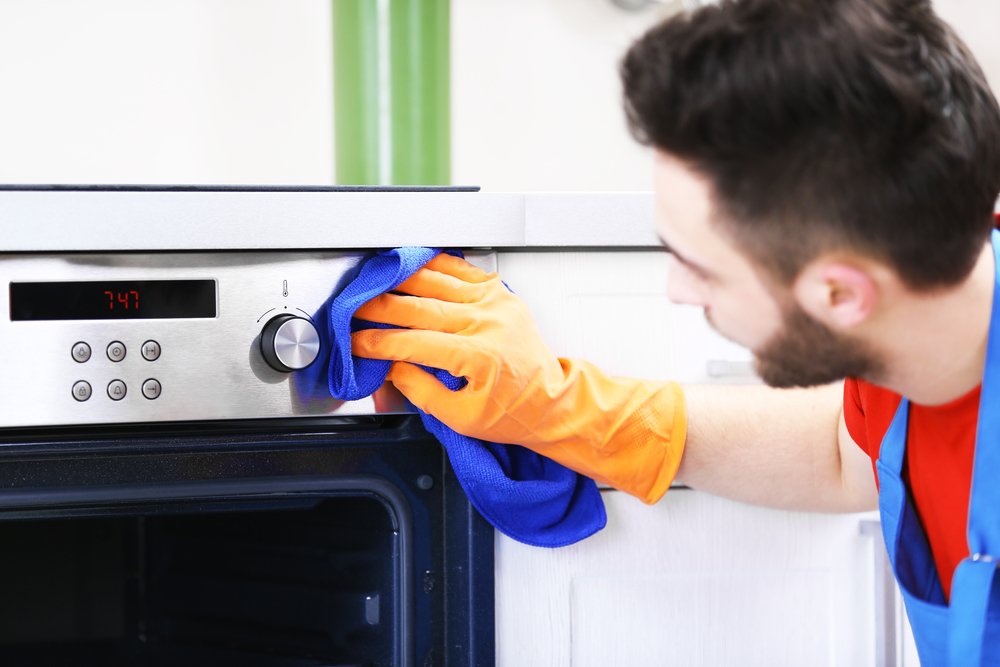 Persona limpiando el horno de la cocina-Imagen tomada de Shutterstock