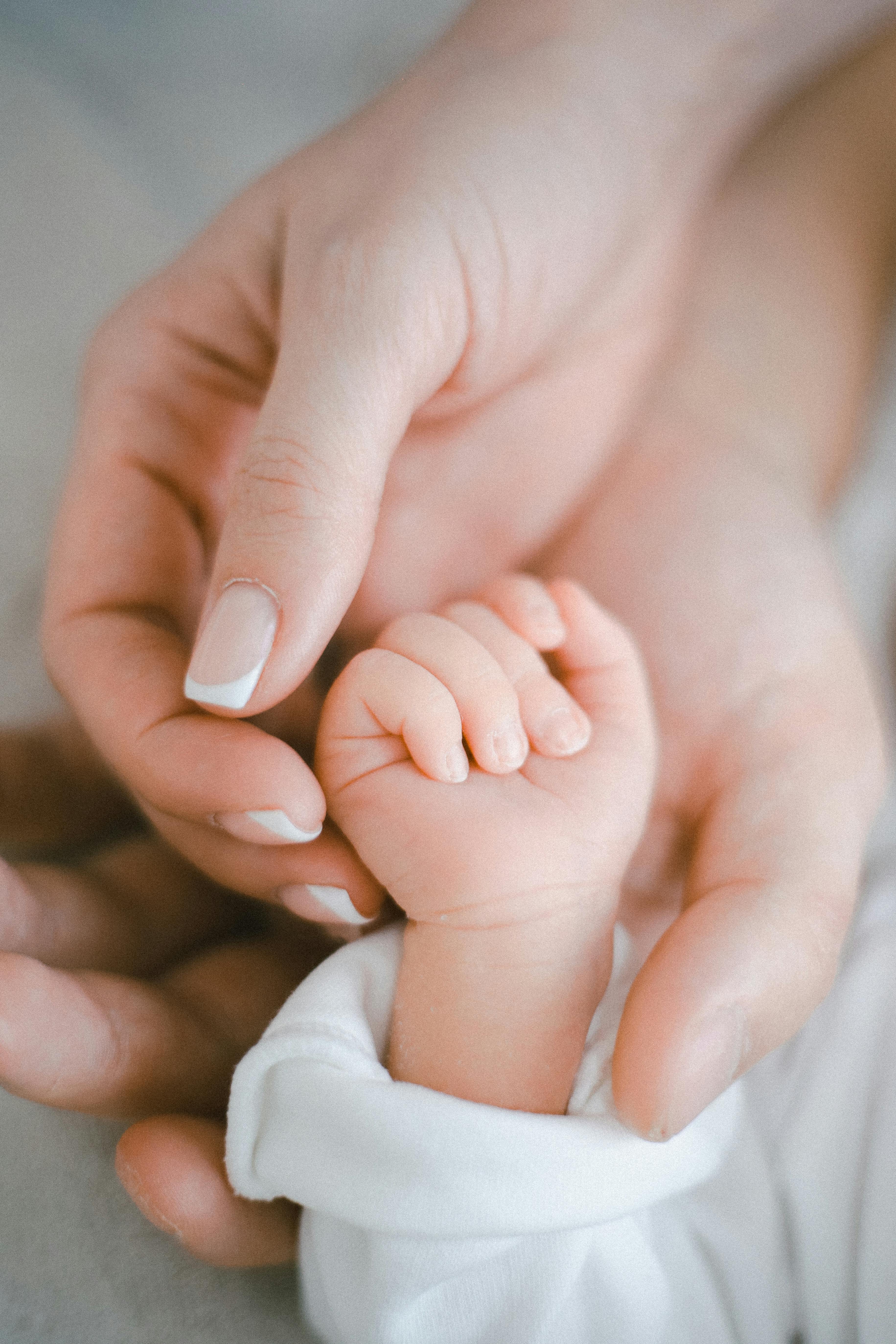Las manos de los padres sujetando a su pequeño | Fuente: Pexels
