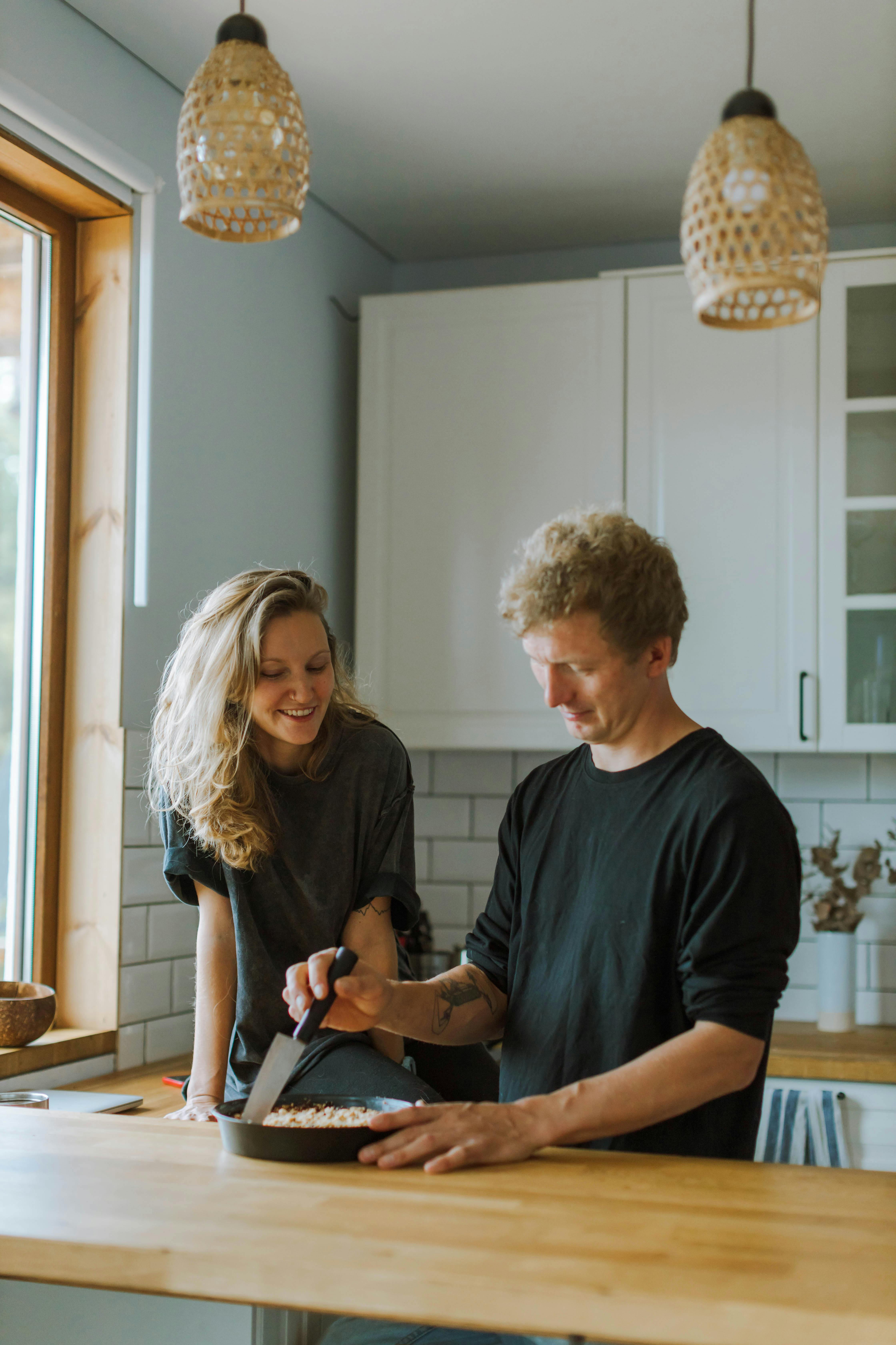 Un hombre y una mujer cocinando juntos en la cocina | Fuente: Pexels