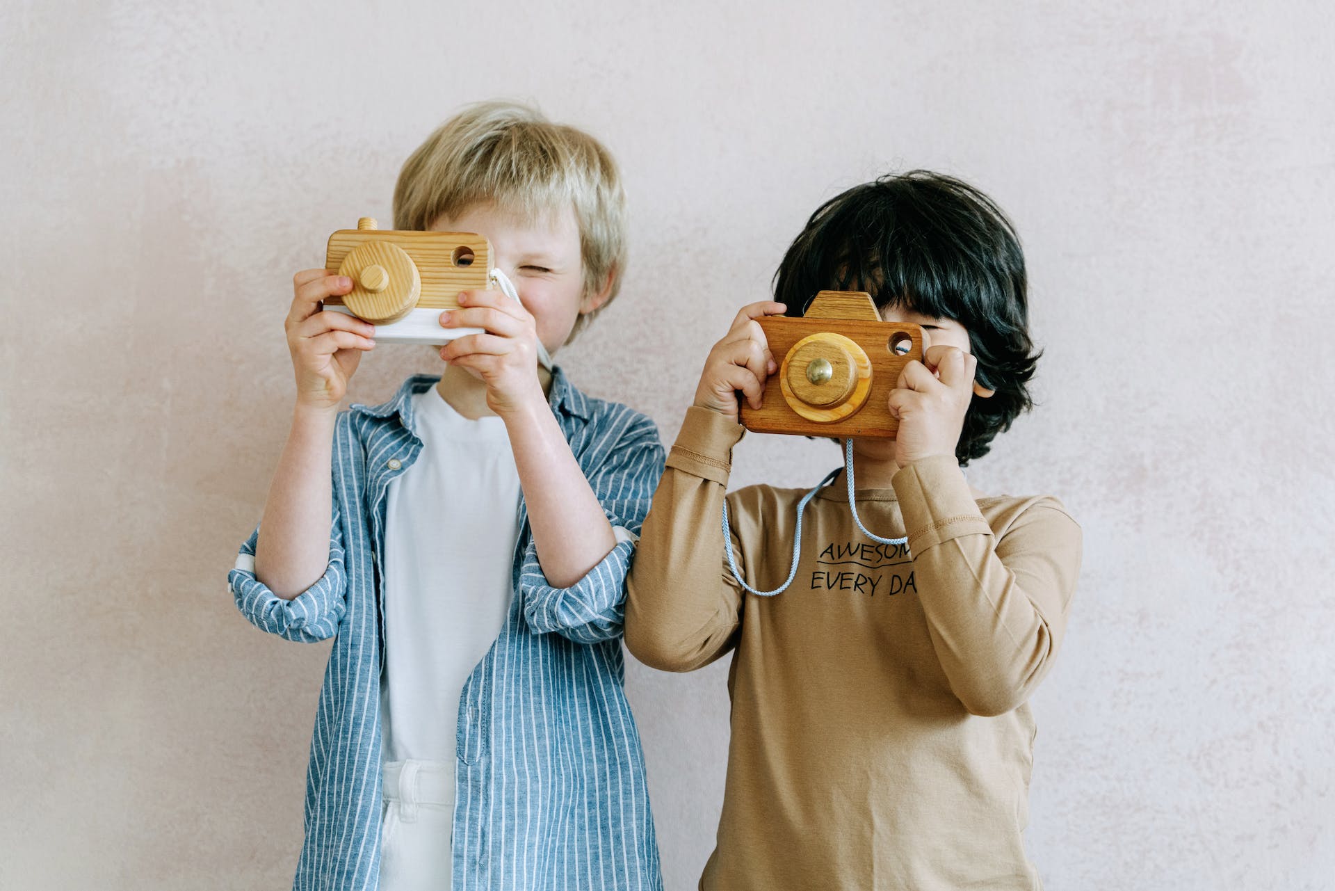 Dos niños jugando con una cámara de juguete | Foto: Pexels