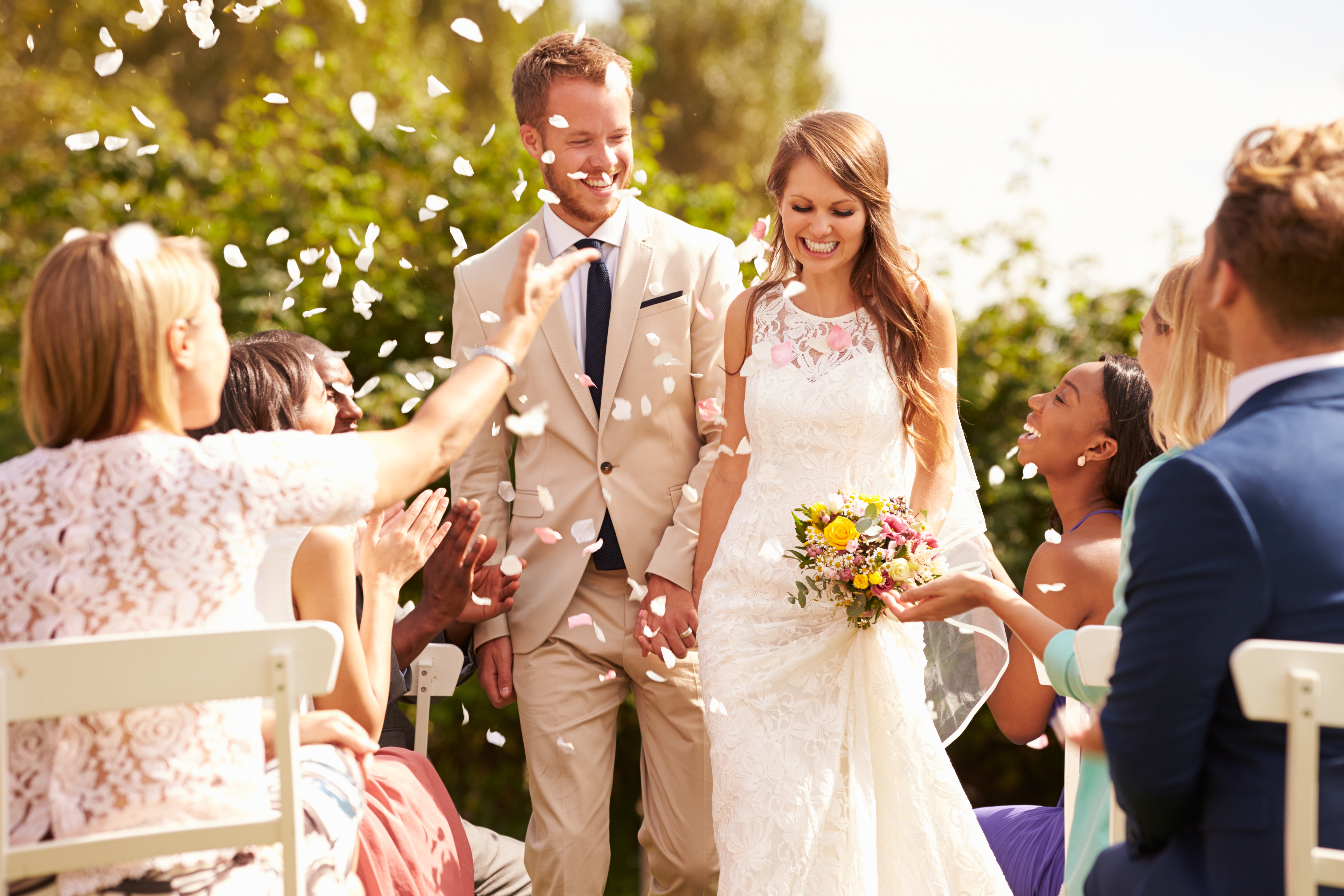 Invitados lanzando confeti sobre los recién casados | Fuente: Shutterstock