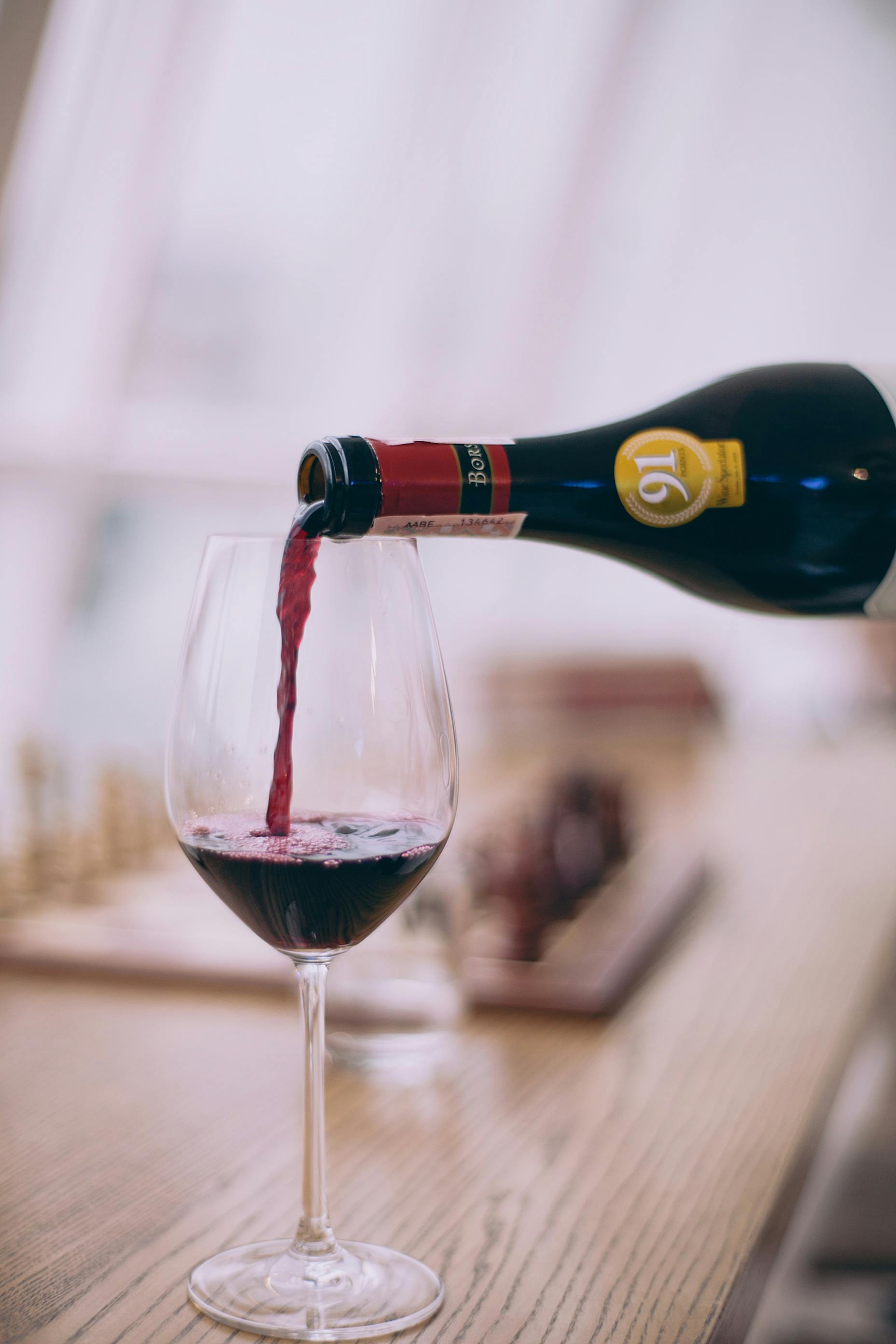 Vino tinto vertido en un vaso | Fuente: Pexels