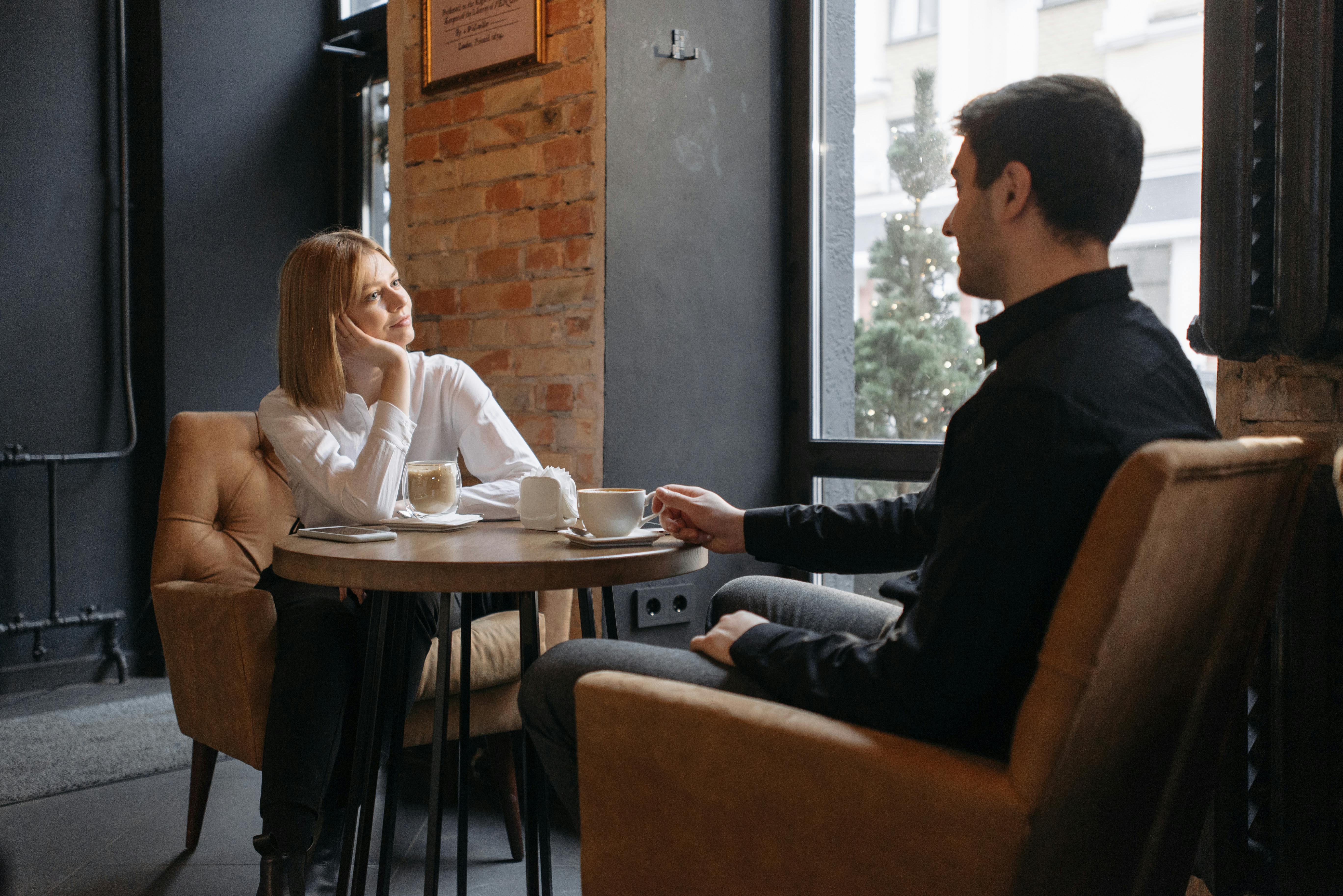 Un hombre y una mujer hablando en un café | Fuente: Pexels