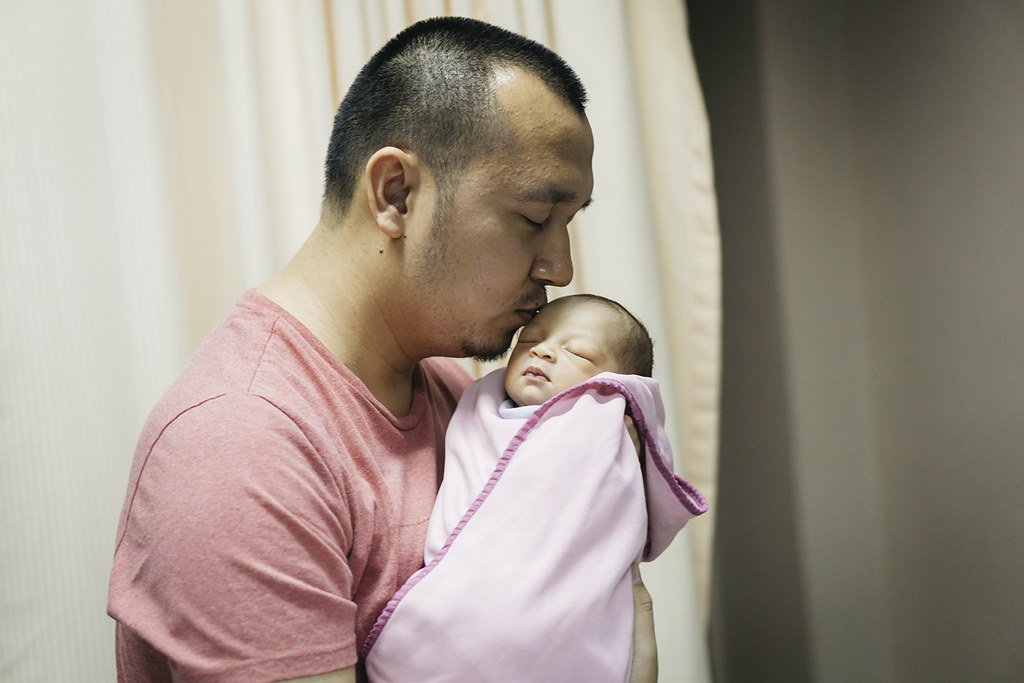 Hombre besando a su bebé recién nacido. | Imagen: Flickr