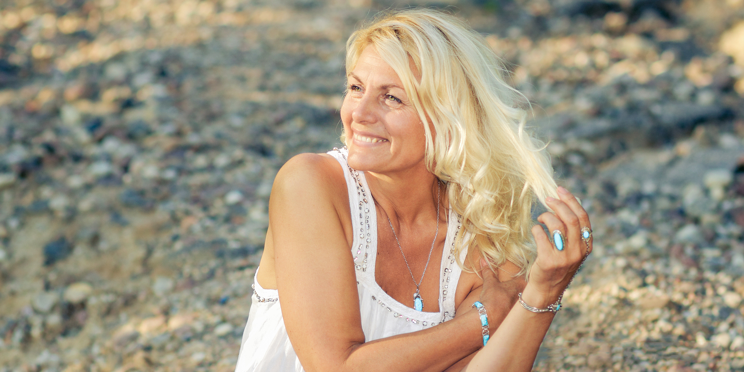 Una mujer sonriente con un vestido blanco | Fuente: Shutterstock