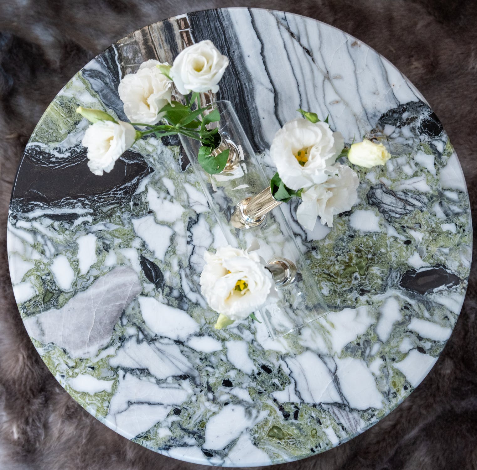 Contenedor de vidrio con rosas blancas sobre un plato de mármol. | Foto: Pexels