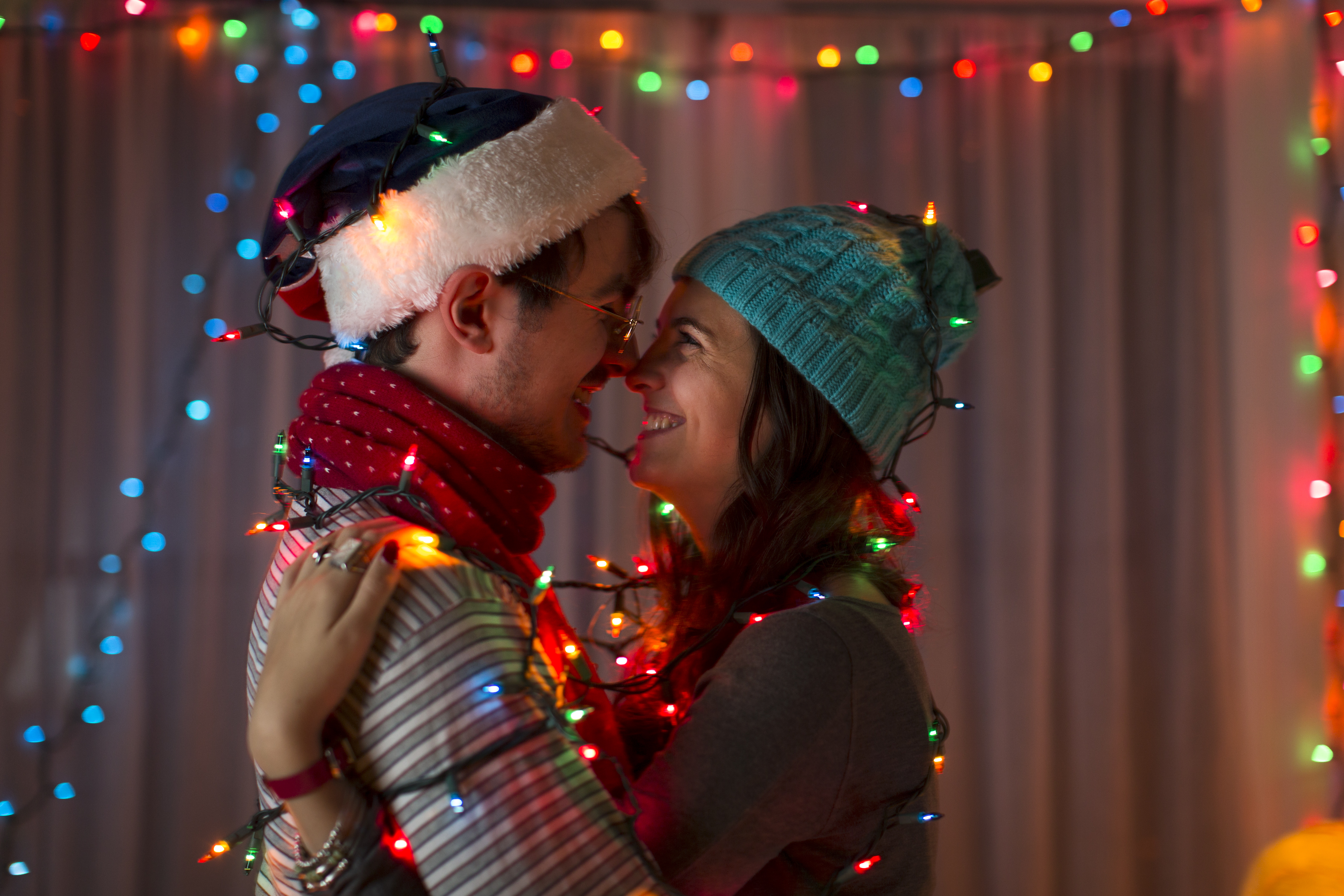 Pareja rodeada de luces decorativas en Navidad | Foto: Getty Images