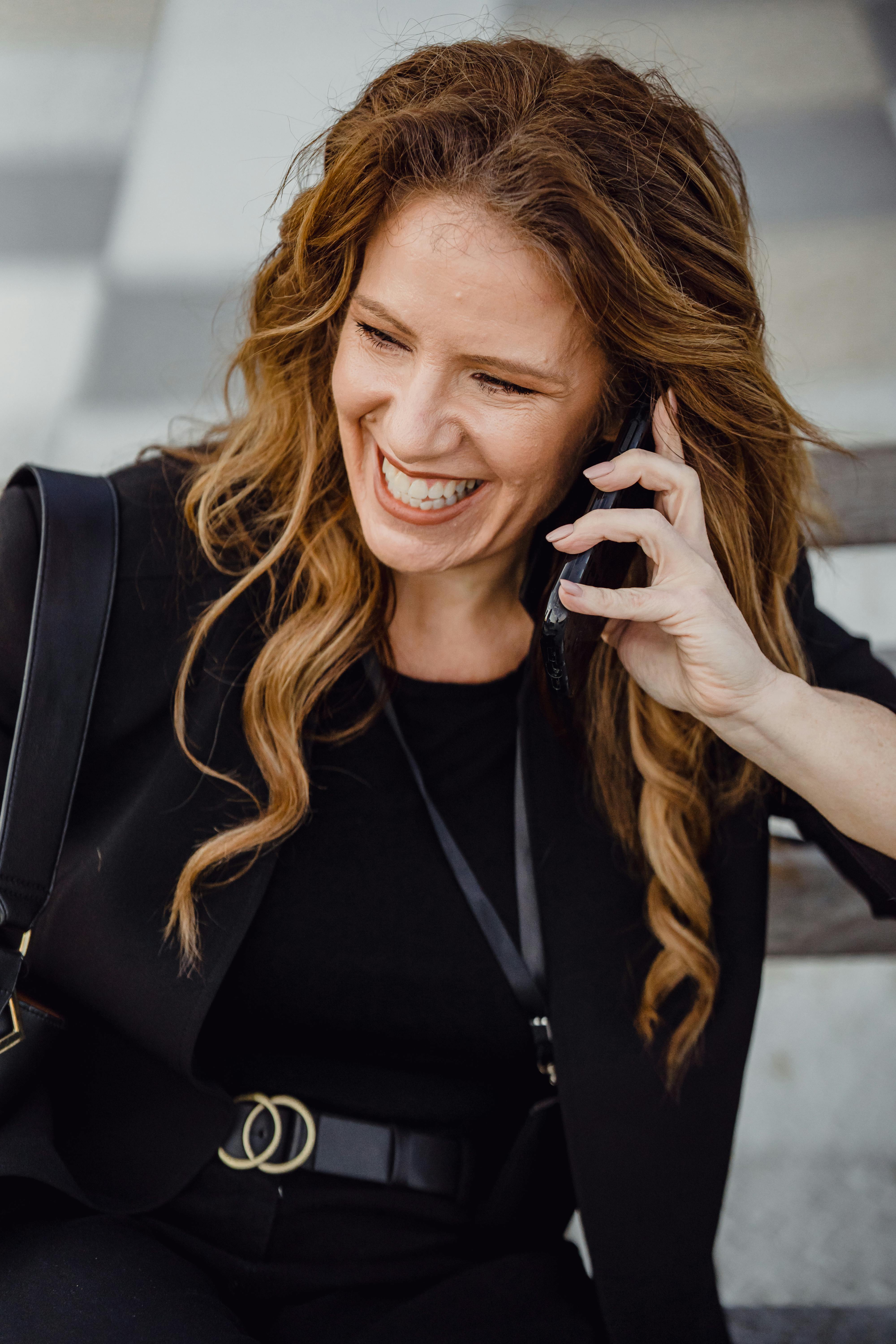 Una mujer feliz hablando por teléfono | Fuente: Pexels