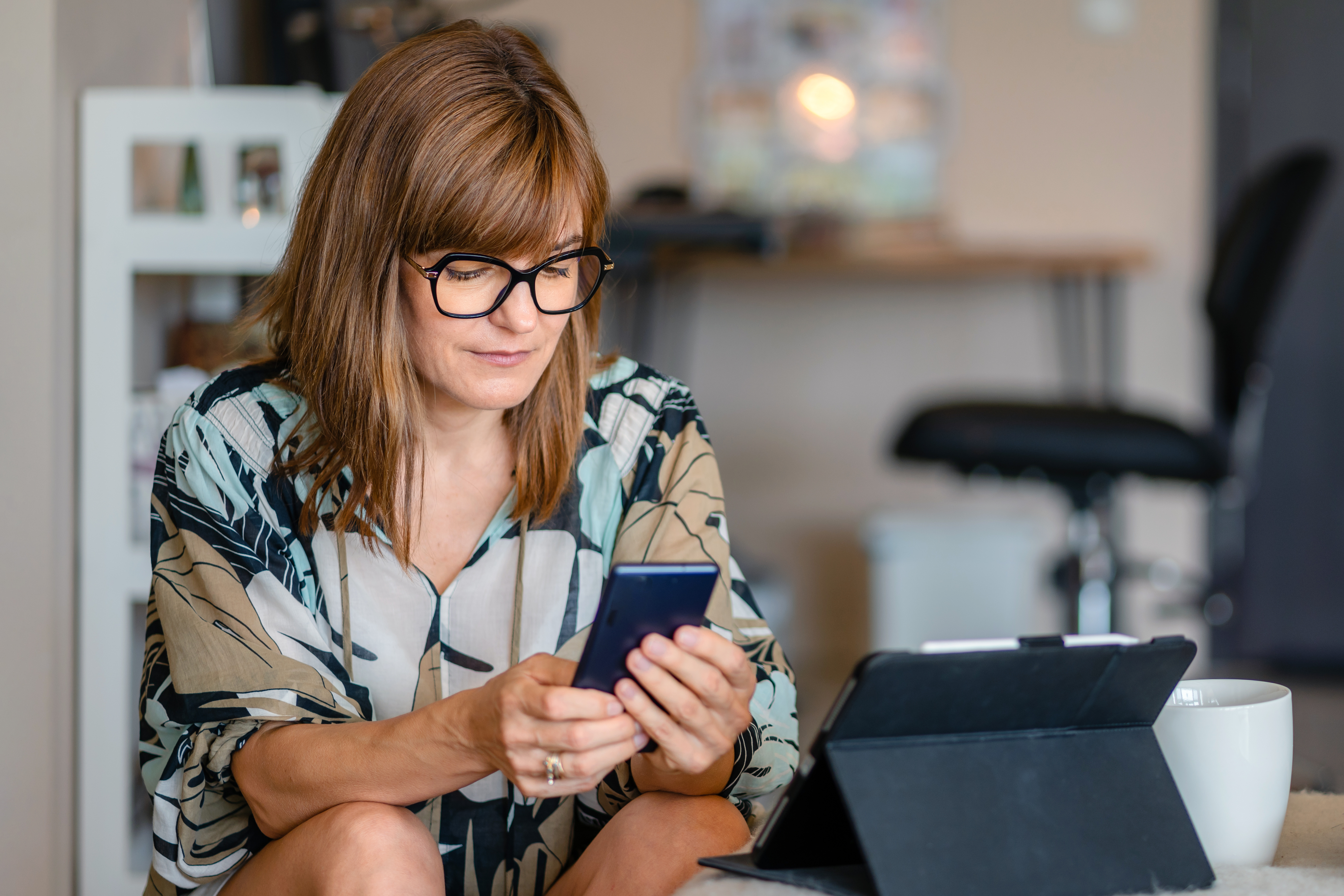 Mujer de negocios soltera y seria usando el teléfono en casa | Fuente: Getty Images