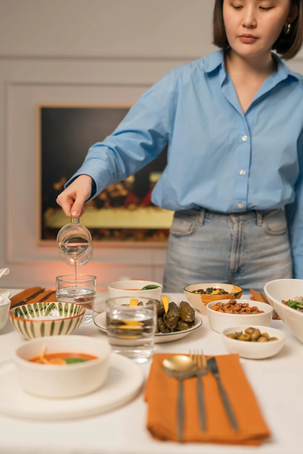 Una mujer poniendo la mesa ⏐ Fuente: Pexels