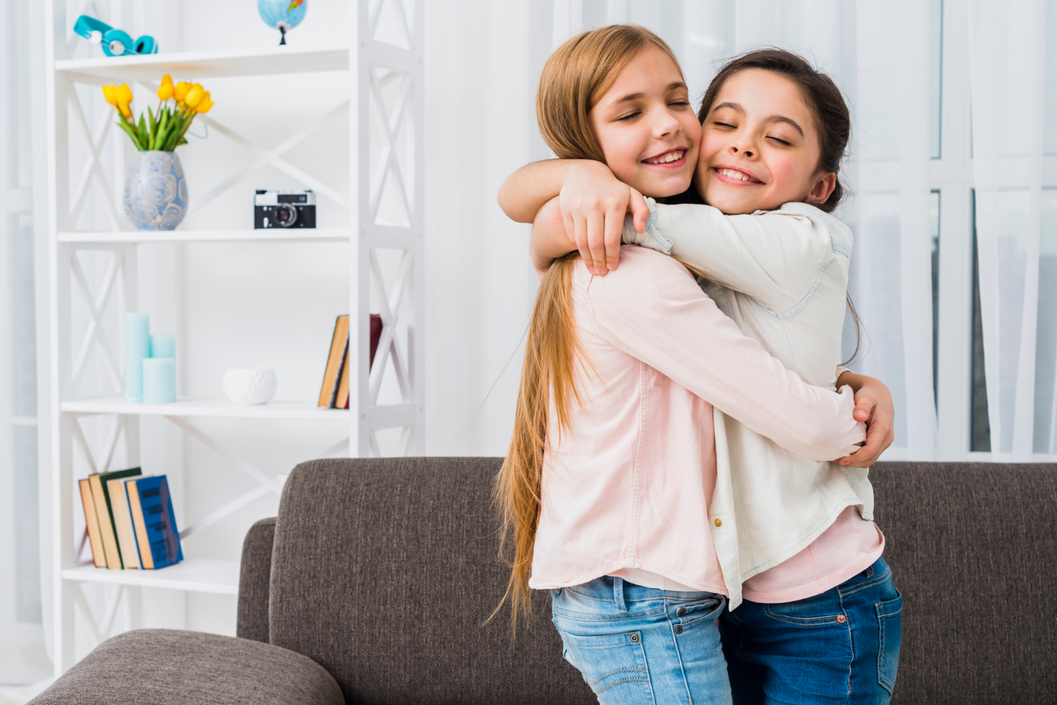 Dos chicas sonrientes abrazándose | Fuente: Freepik