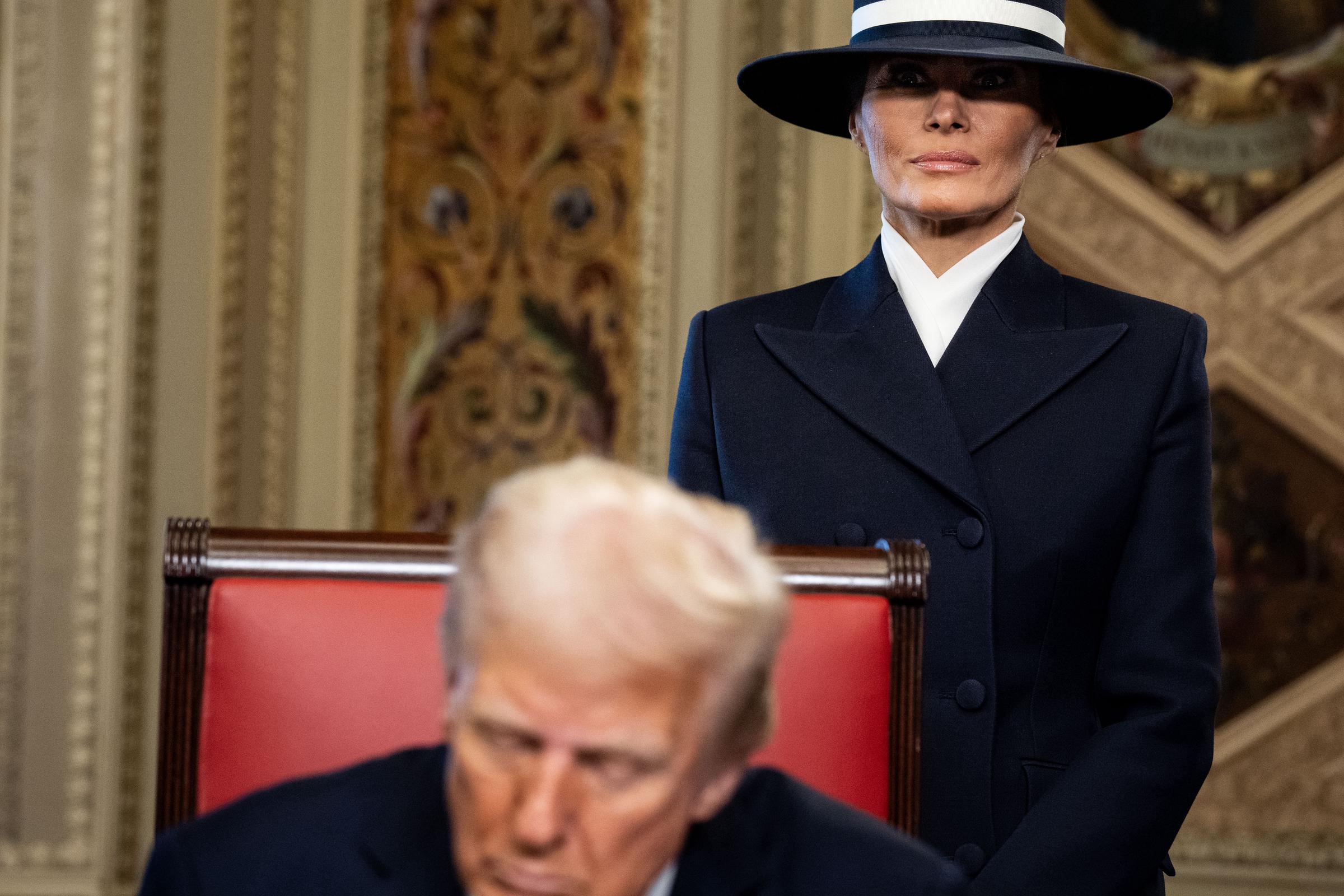 El Presidente Donald Trump firmando documentos oficiales en la Sala Presidencial con la Primera Dama Melania Trump al fondo el 20 de enero de 2025, en el Capitolio de EE.UU. en Washington, D.C. | Fuente: Getty Images