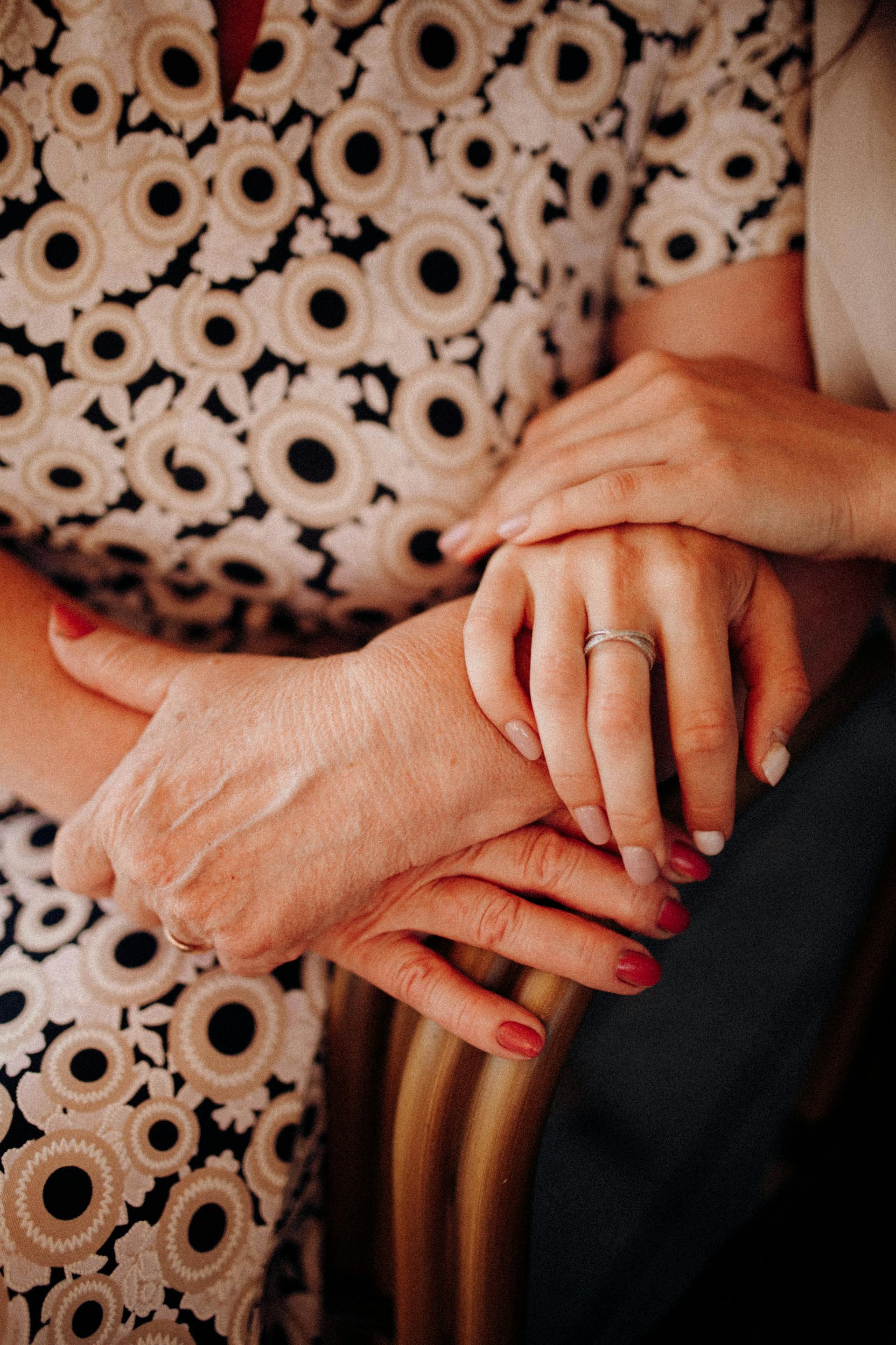 Una mujer tocando las manos de su madre | Fuente: Pexels