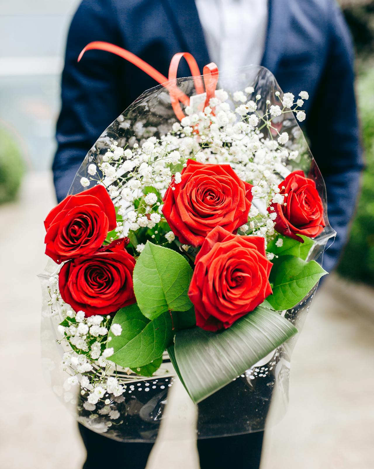 Un hombre con un ramo de rosas rojas | Fuente: Pexels