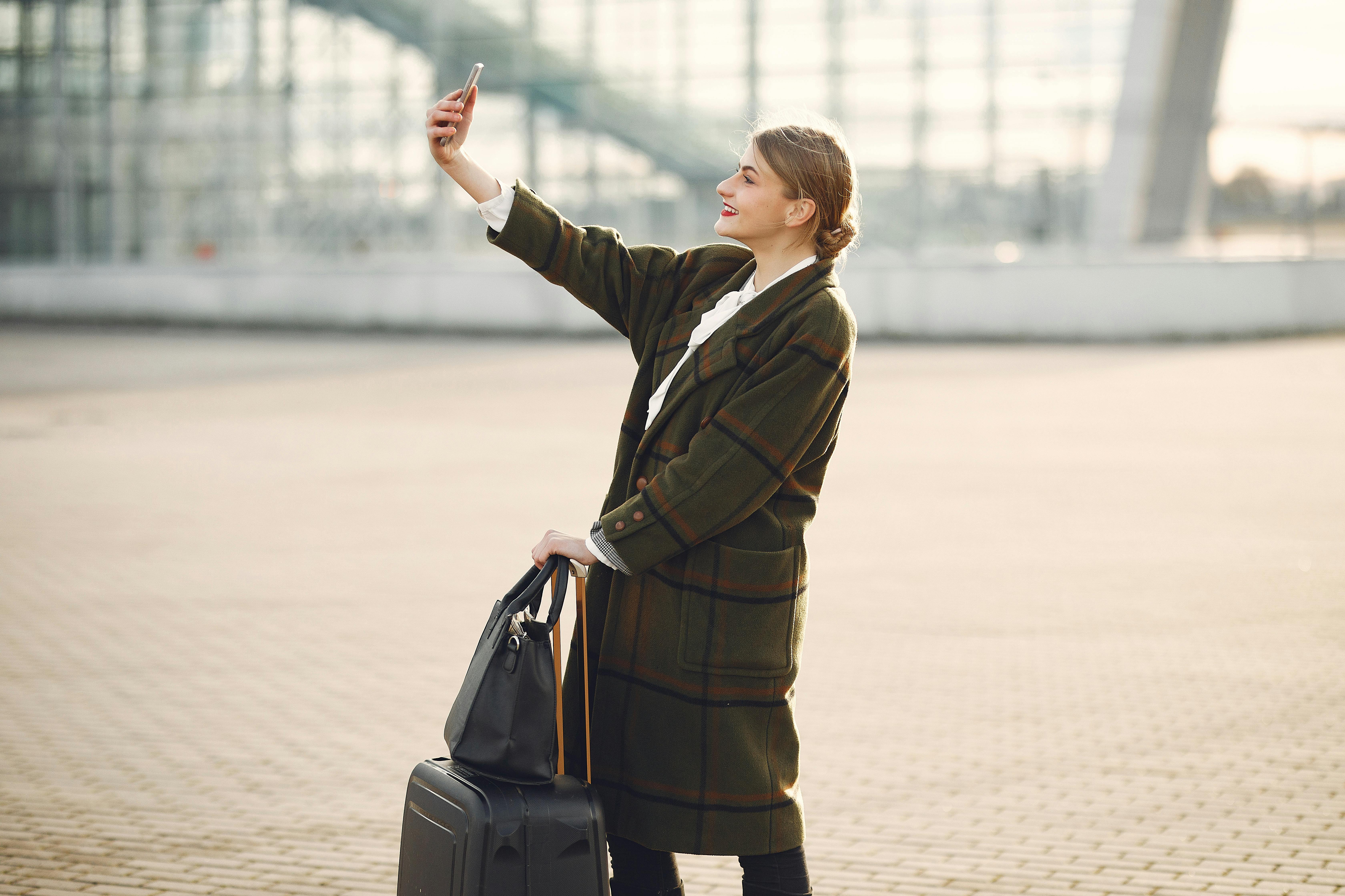 Una mujer mirando su teléfono en un aeropuerto | Fuente: Pexels