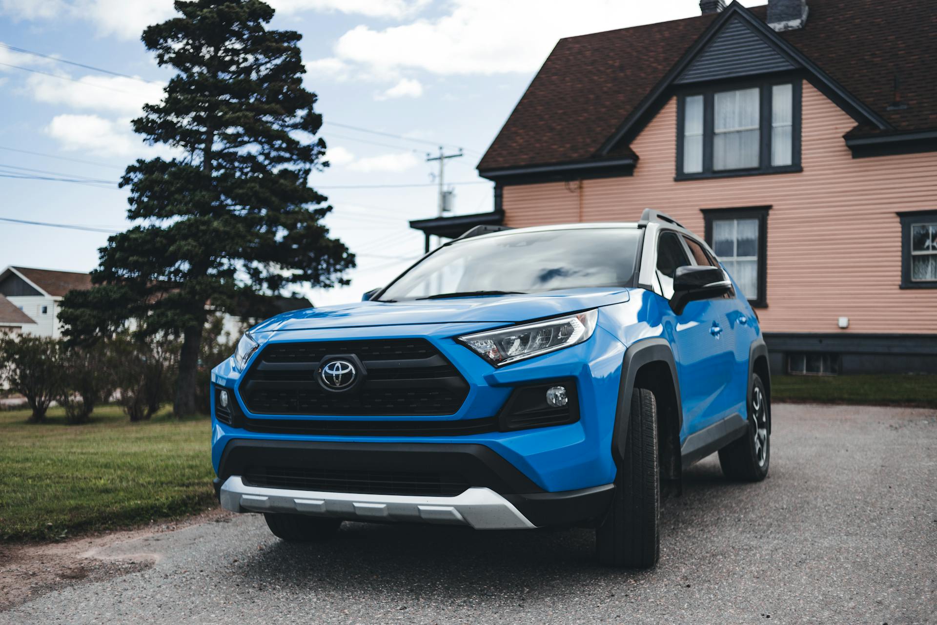 Un automóvil azul aparcado cerca de una casa | Fuente: Pexels