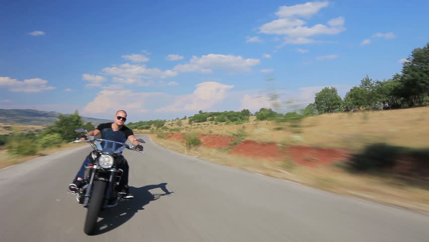 Hombre en una motocicleta personalizada en un camino abierto. | Imagen: Shutterstock