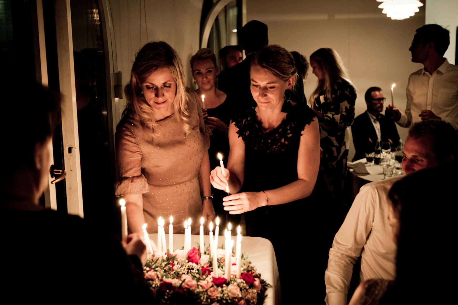 Dos mujeres sosteniendo velas en una fiesta de cumpleaños | Fuente: Pexels
