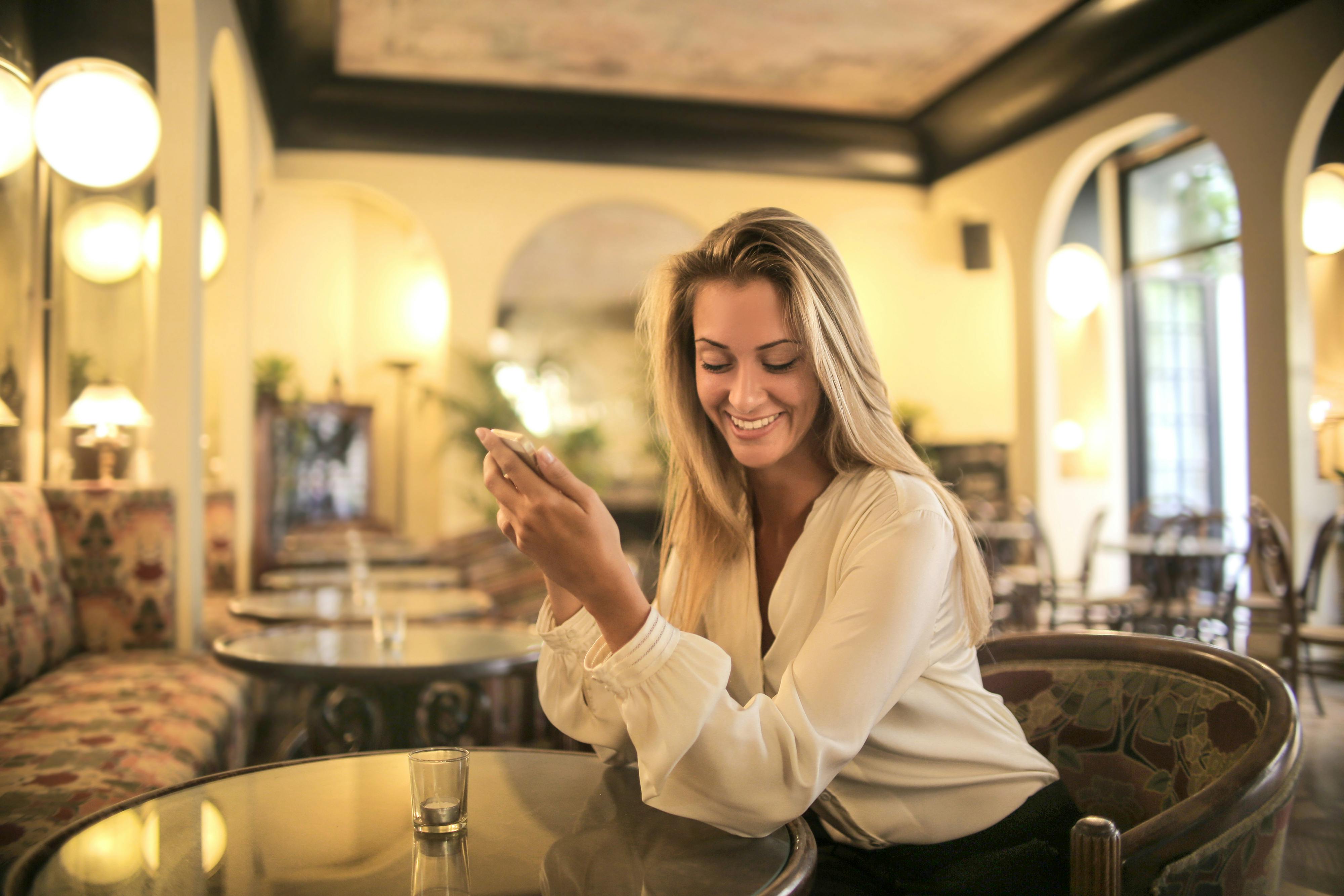 Una mujer enviando mensajes de texto mientras está en un restaurante | Fuente: Pexels