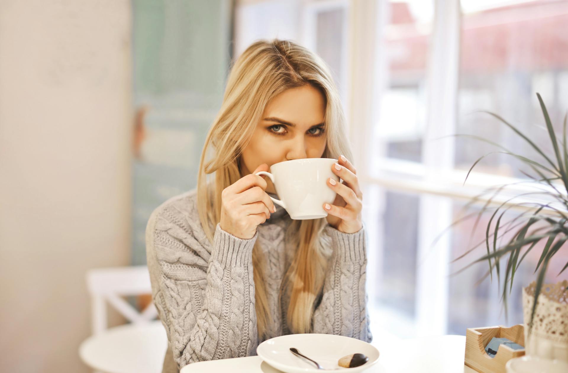 Uma mulher com uma caneca de cerâmica branca | Fonte: Pexels