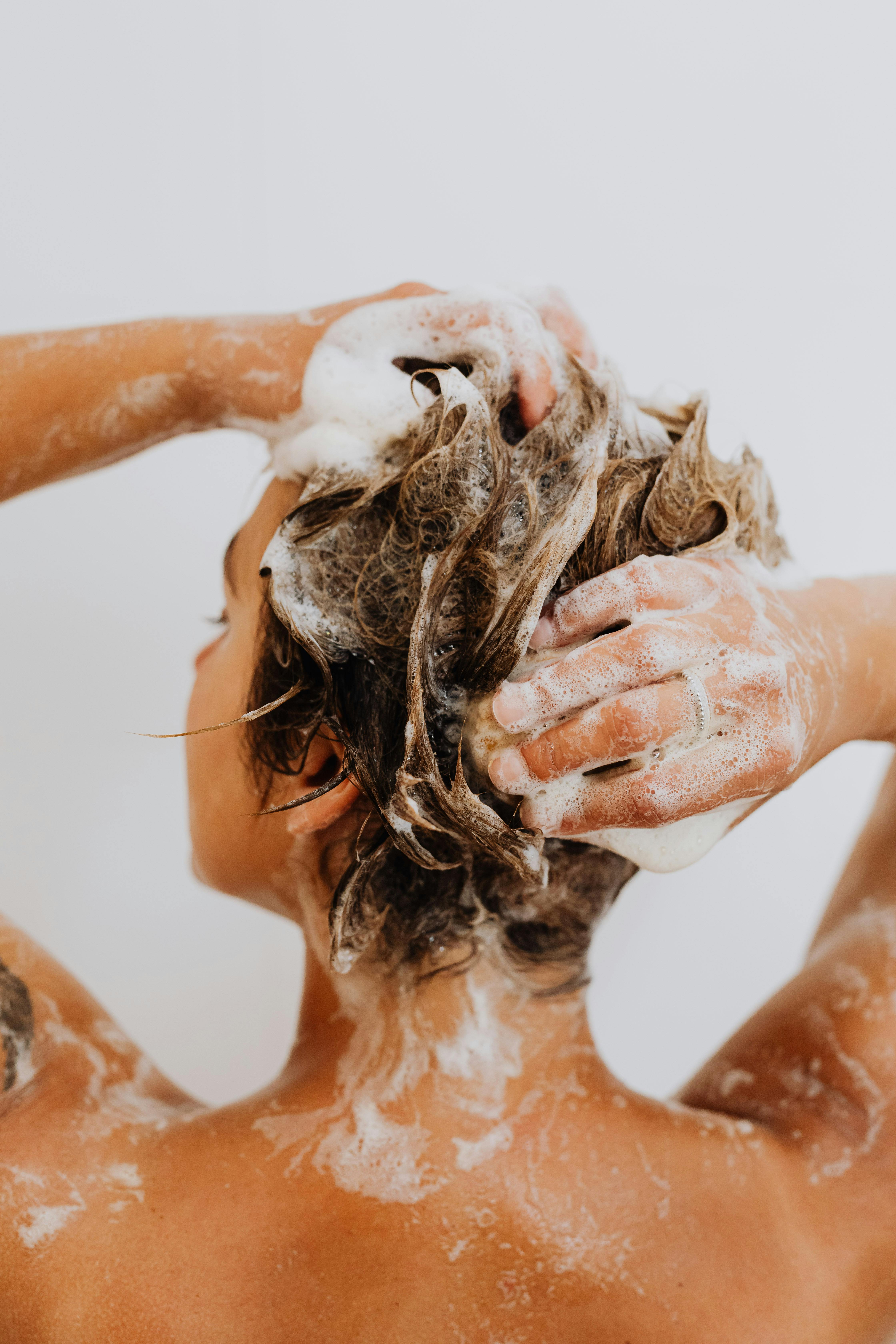 Mujer lavándose el pelo en la ducha | Fuente: Pexels