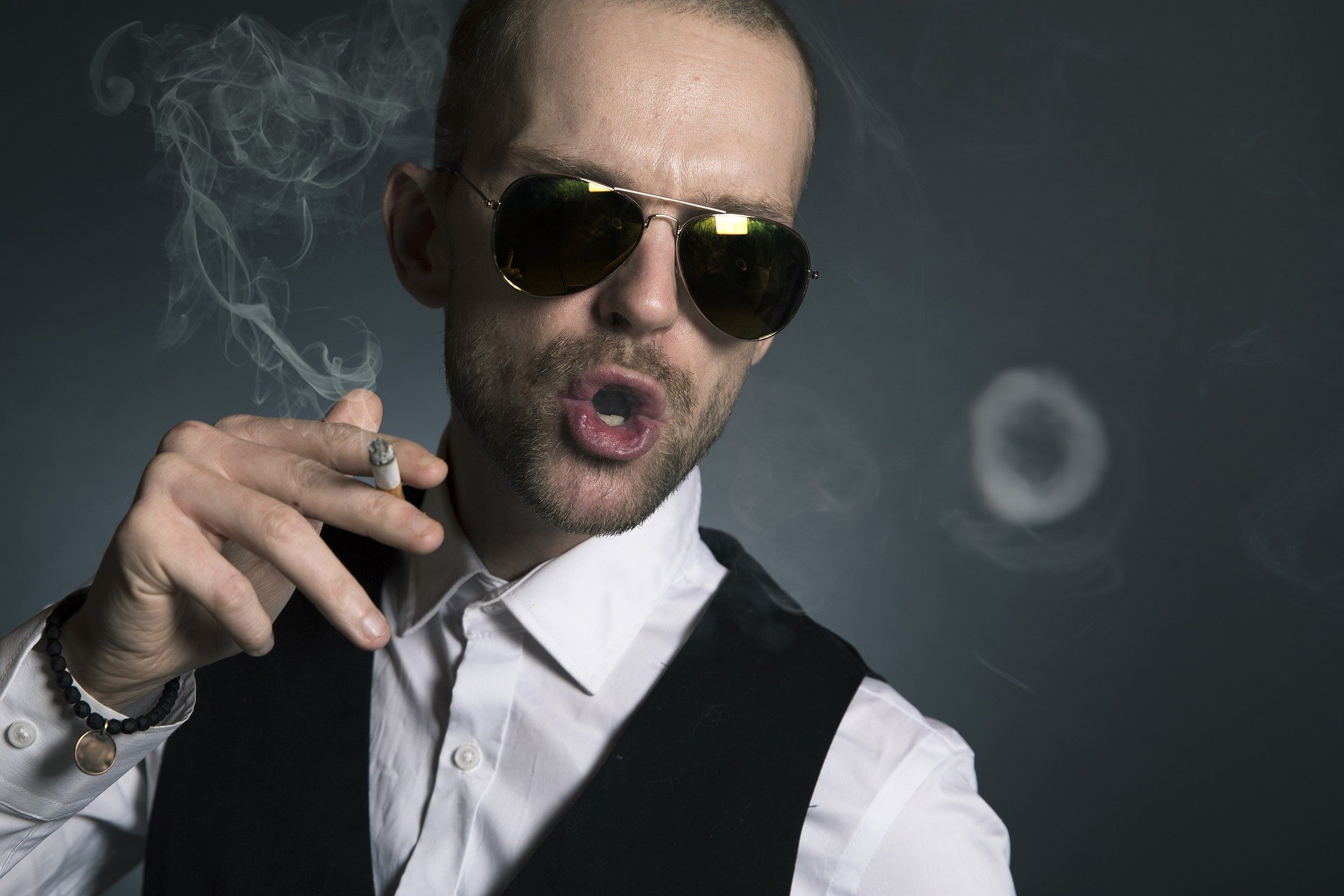 Hombre arrogante con lentes fumando. | Foto; Pixabay