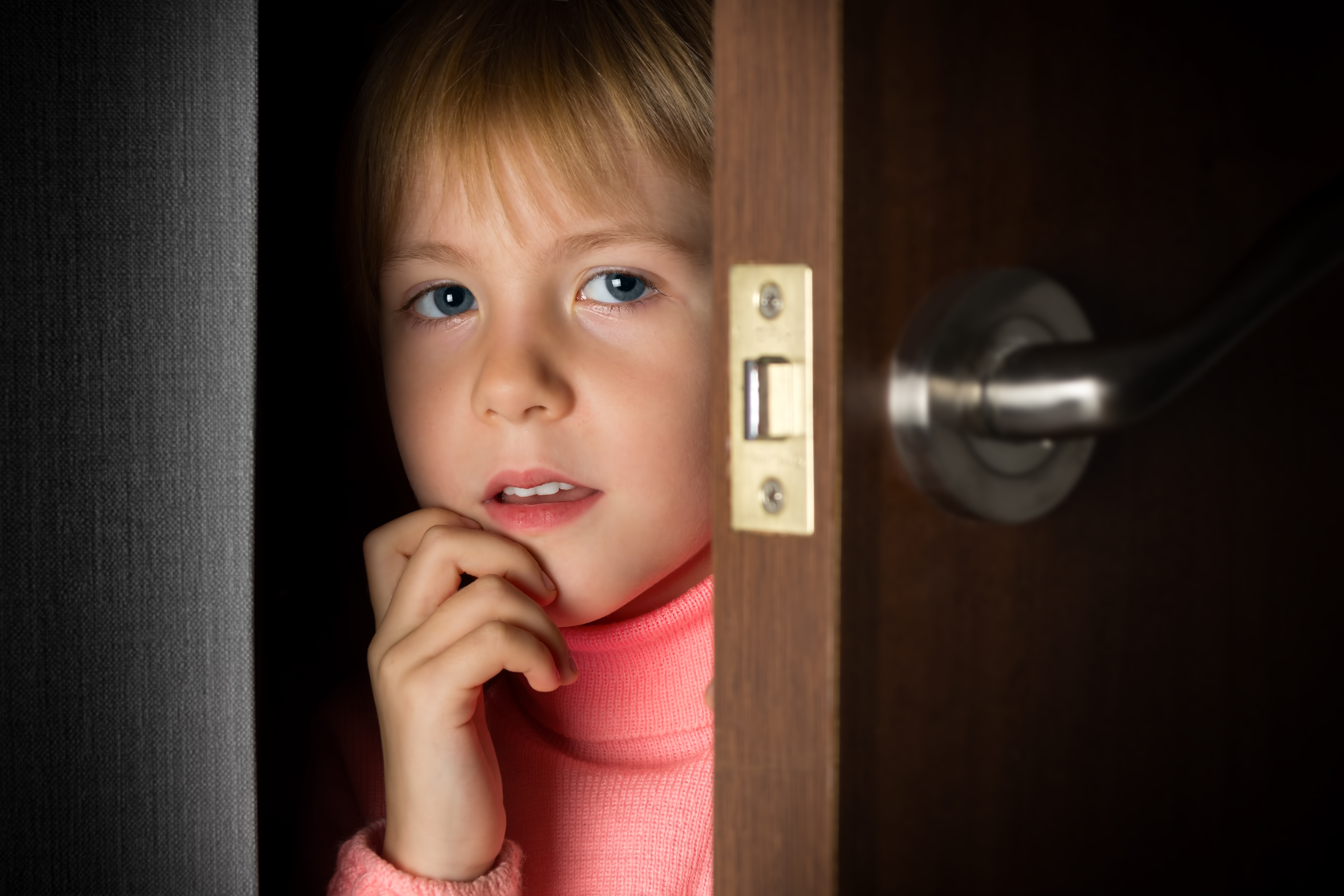 Una niña asomándose por una puerta | Foto: Shutterstock