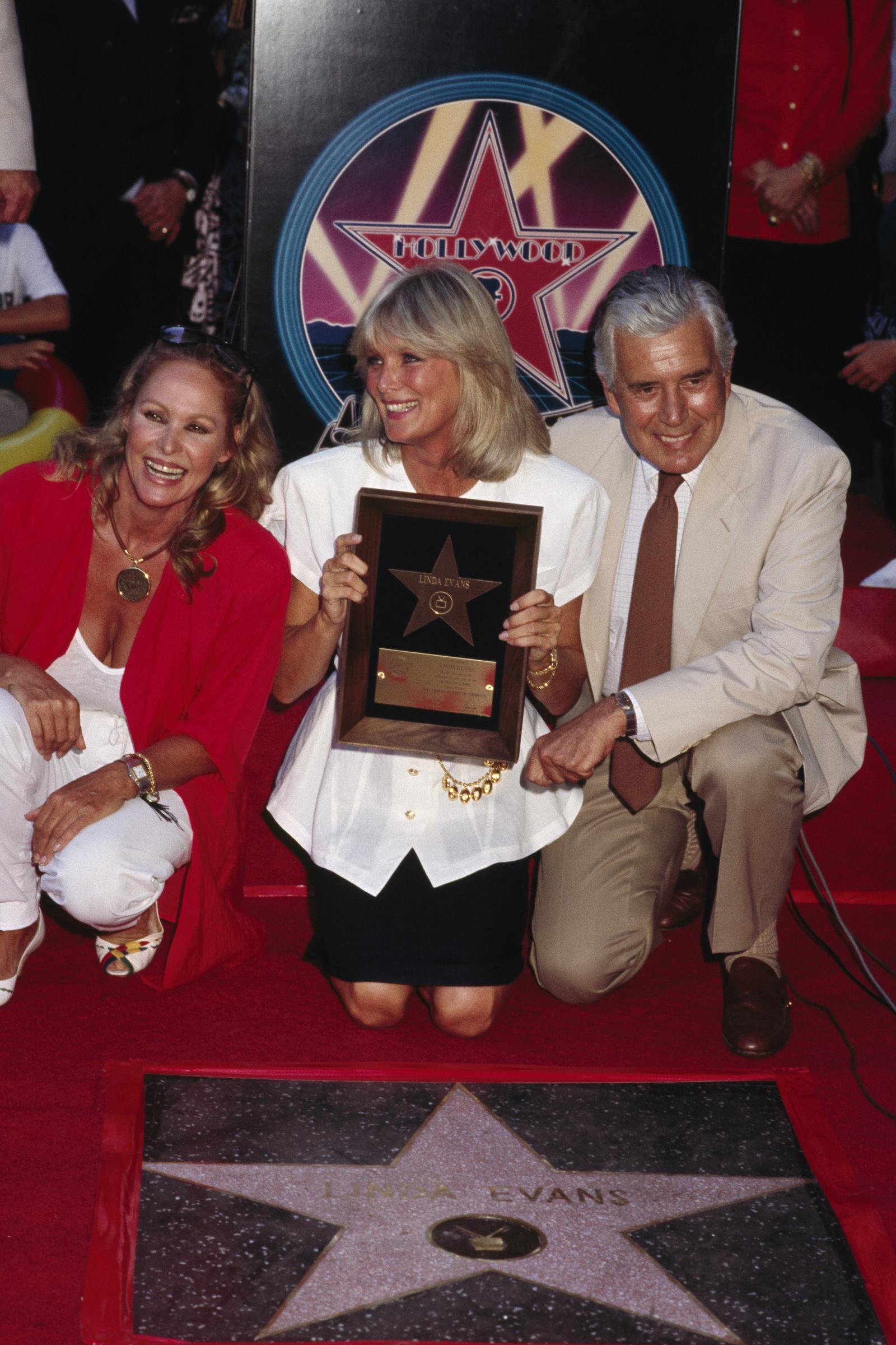 Linda Evans recibe una estrella en el Paseo de la Fama de Hollywood acompañada por John Forsythe el 21 de agosto de 1987 | Fuente: Getty Images