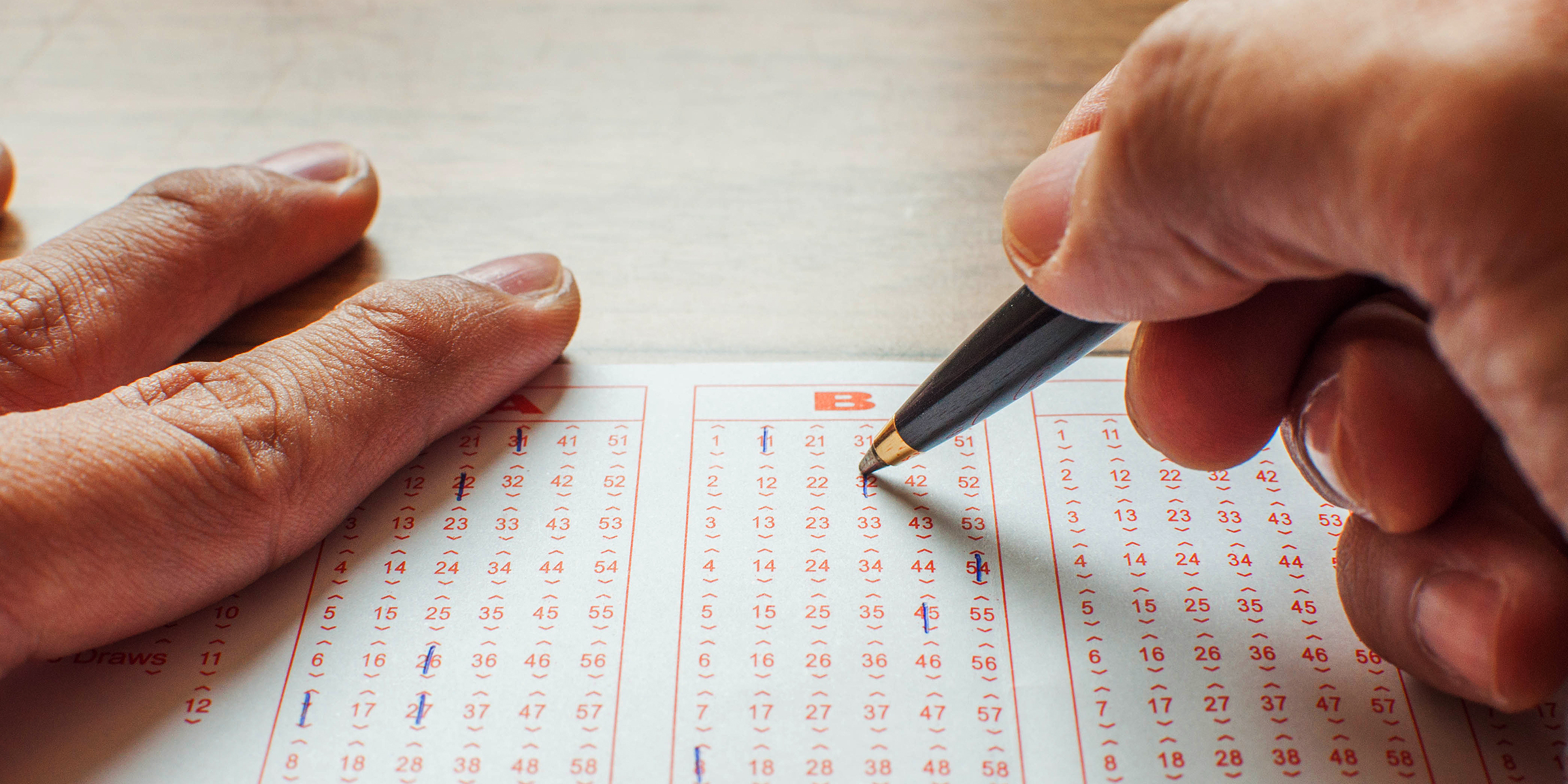 Persona seleccionando números en un billete de lotería | Fuente: Getty Images