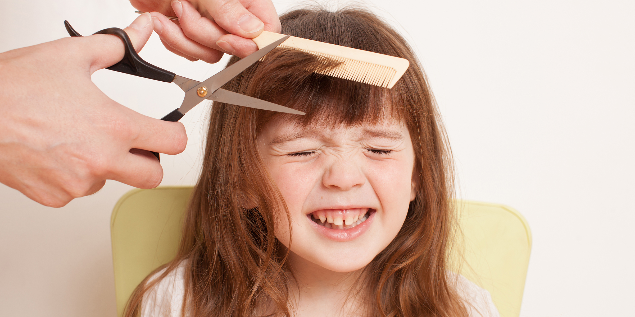 Una persona cortando el pelo a una niña | Fuente: Shutterstock