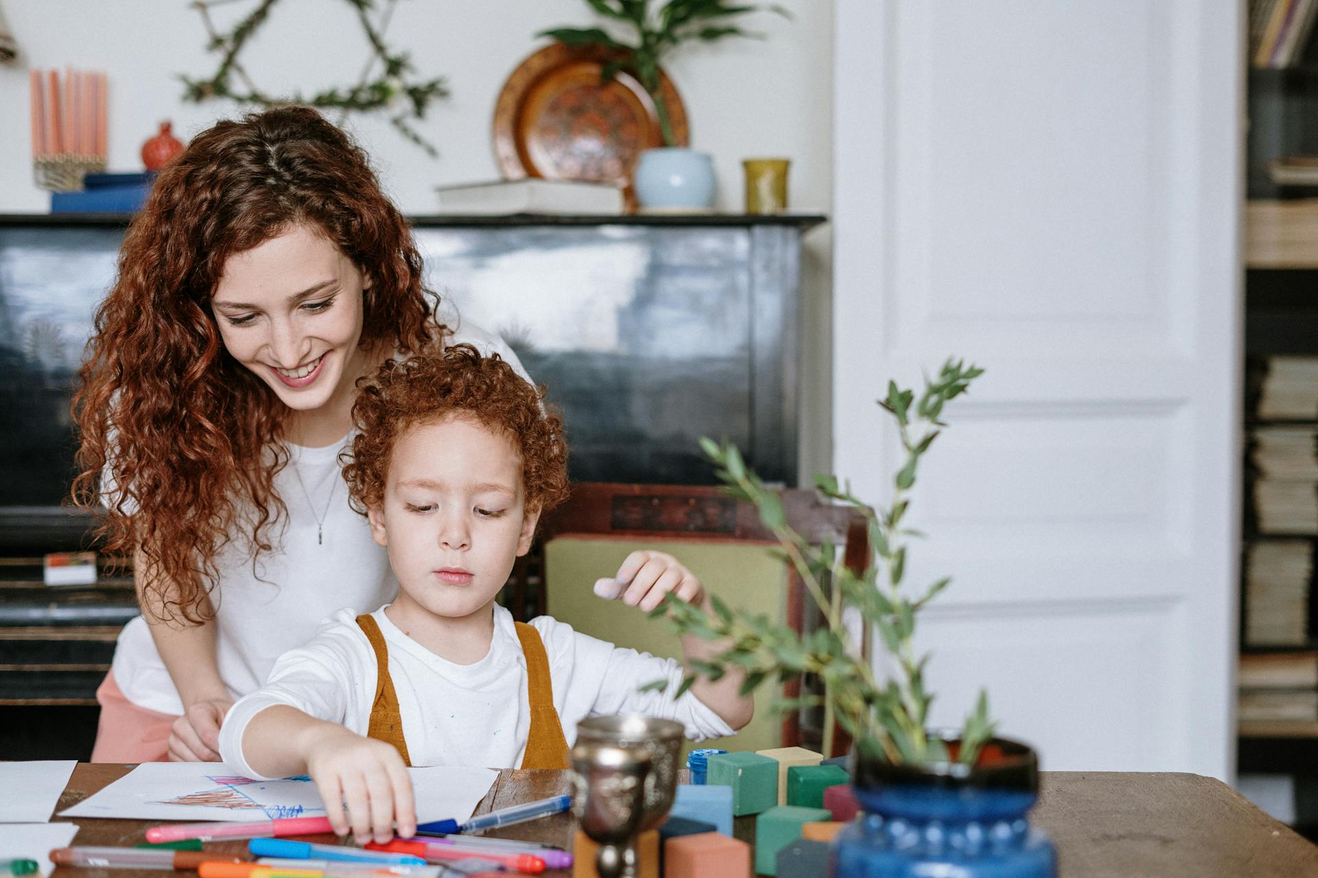 Una mujer mirando cómo dibuja su hijo | Fuente: Pexels